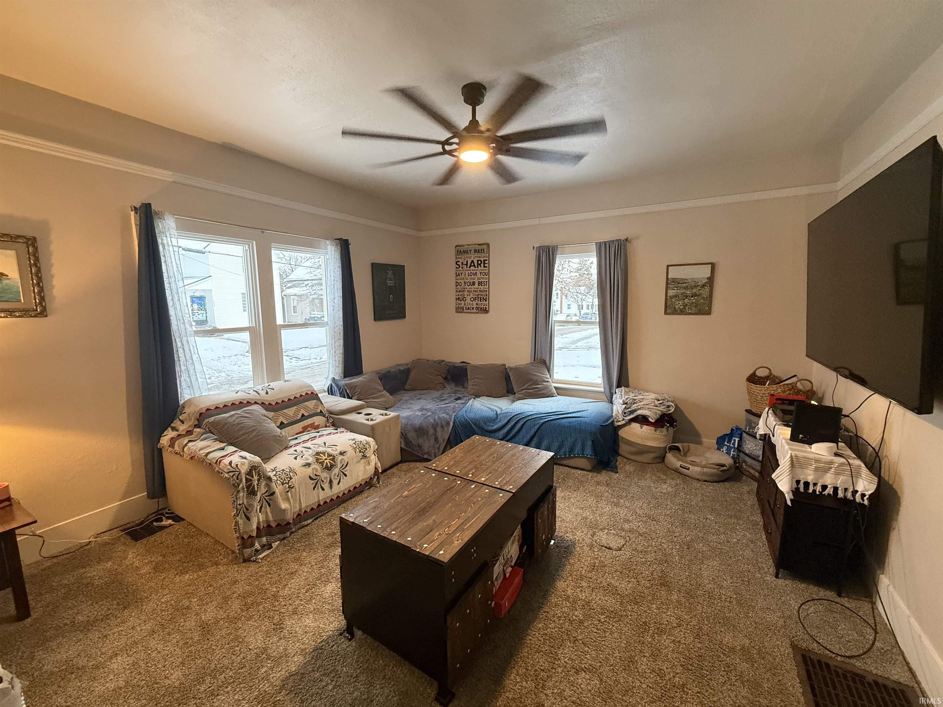 Bedroom featuring multiple windows, a ceiling fan, and carpet floors