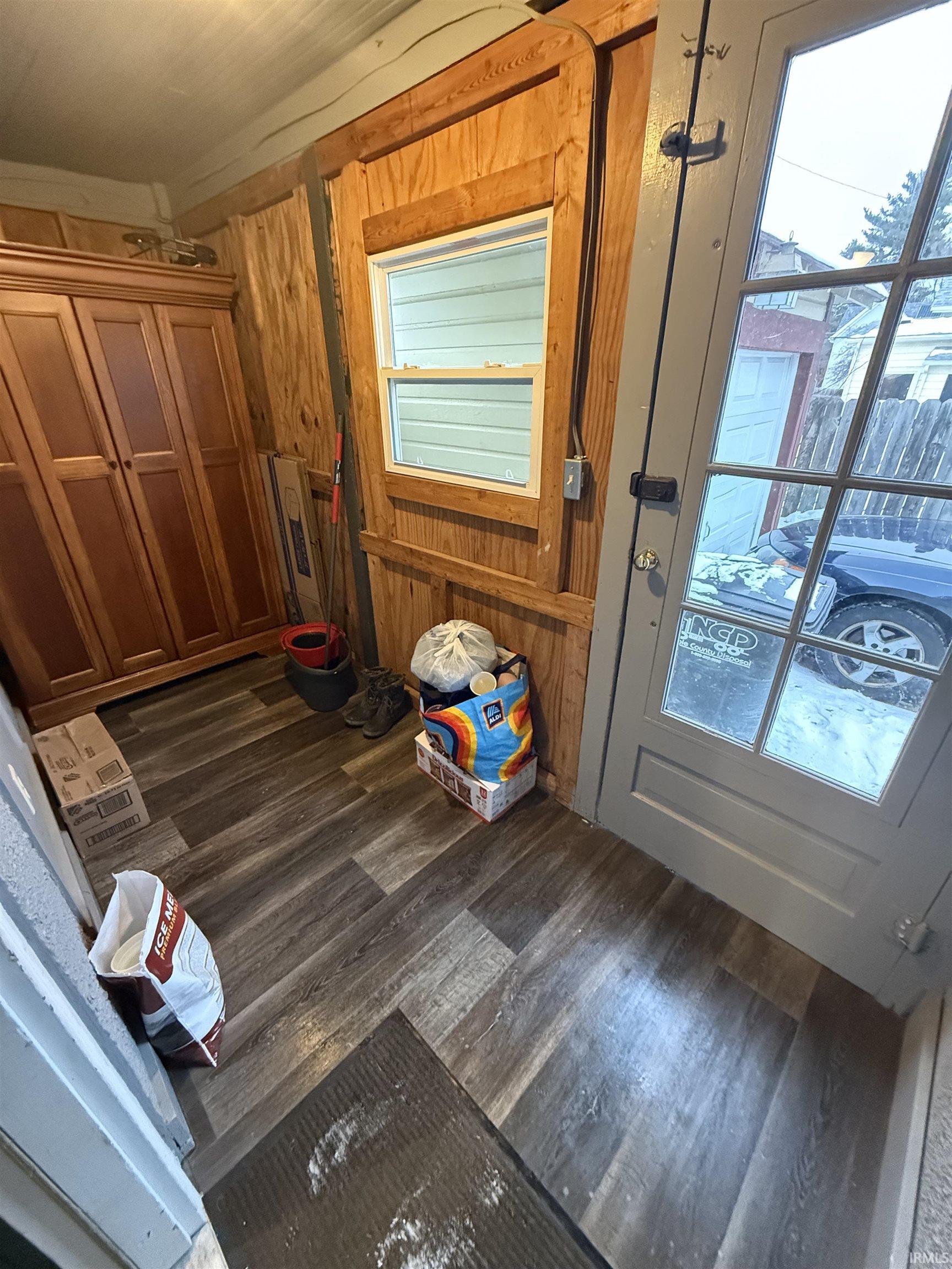 Entryway featuring wood finished floors and wooden walls