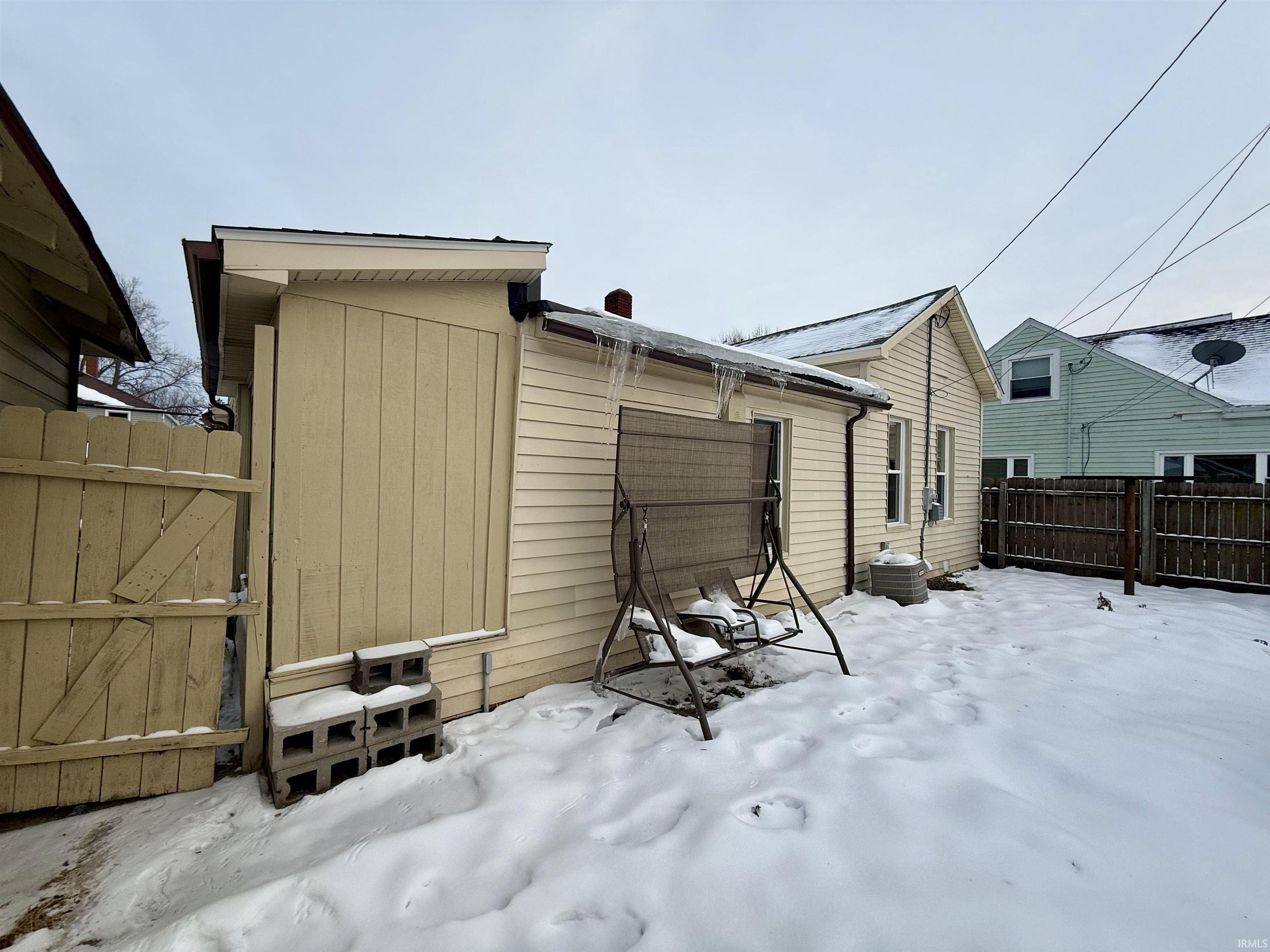 Snow covered property featuring a gate