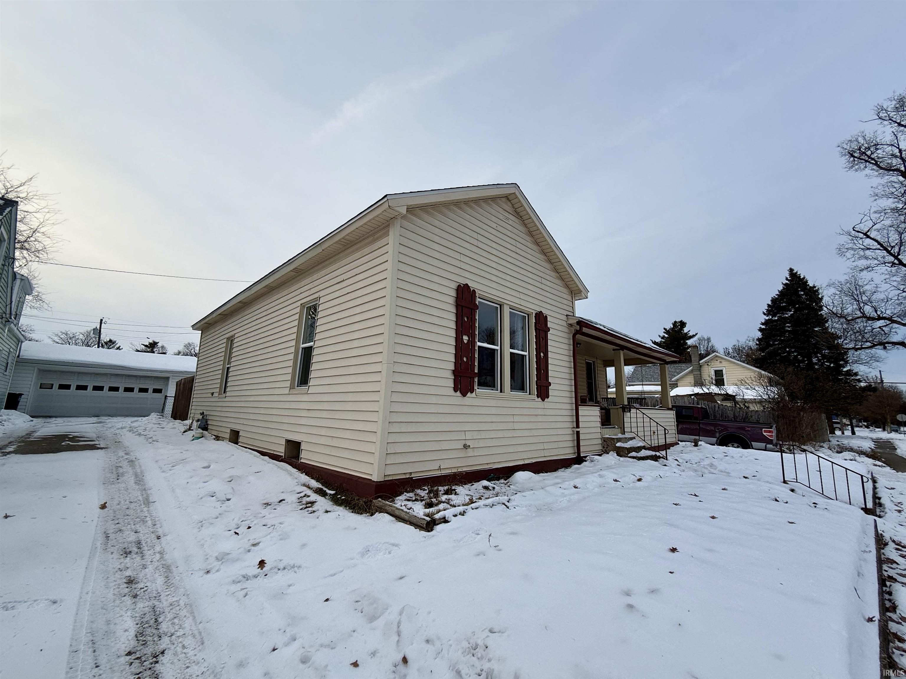 View of front of home with a porch, an outbuilding, and a detached garage