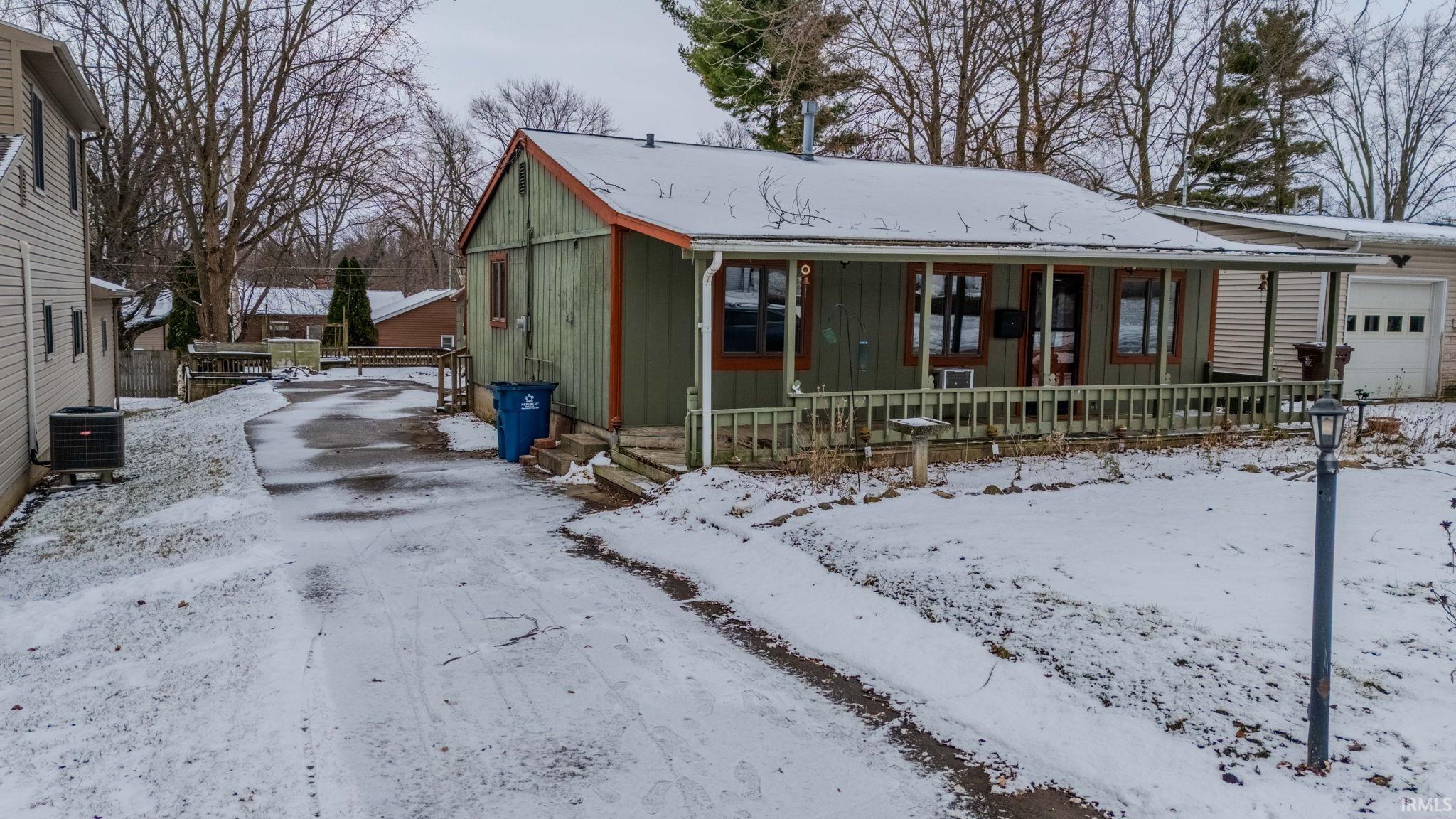 View of front of property featuring a garage and a porch