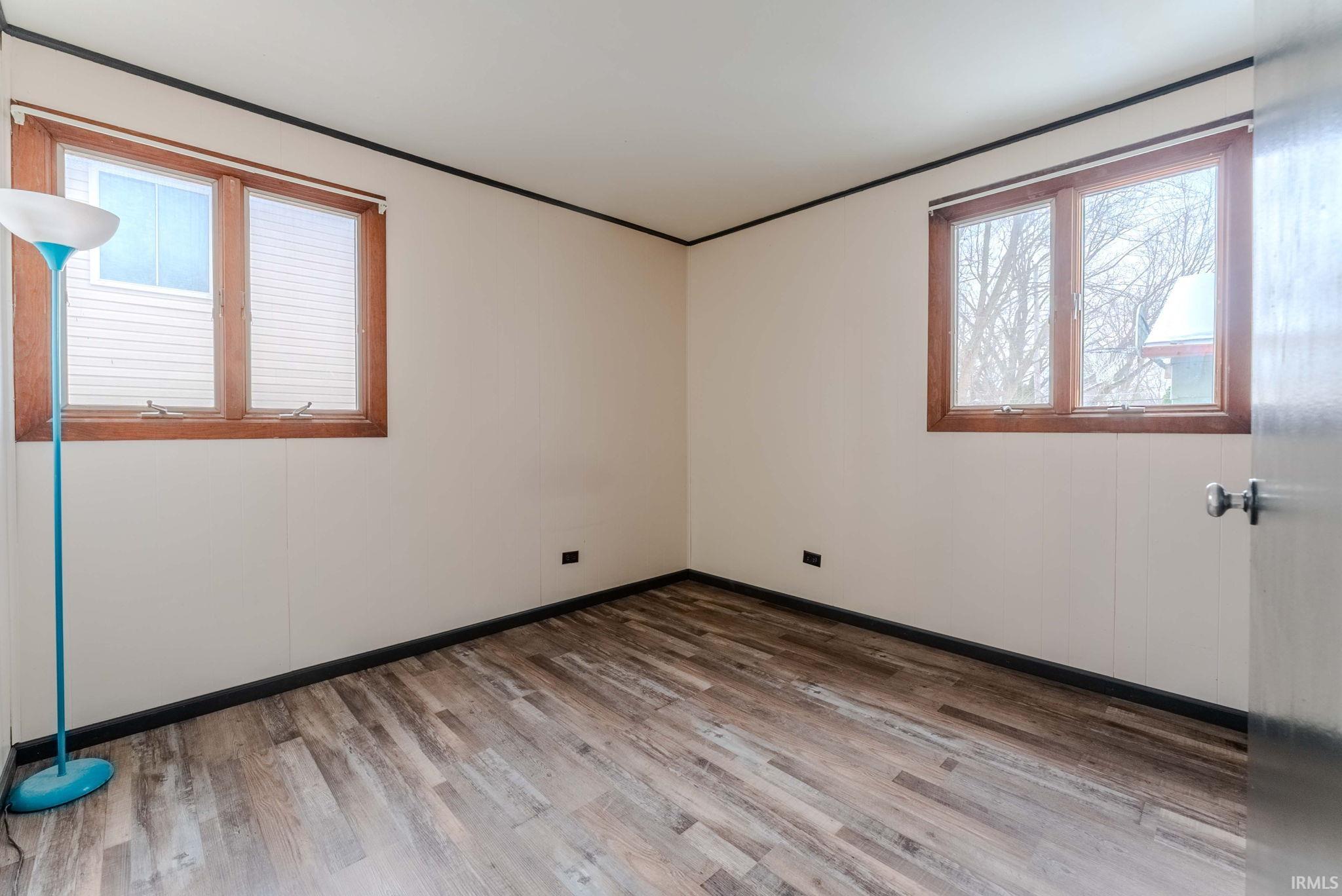 Unfurnished room with wood finished floors and baseboards