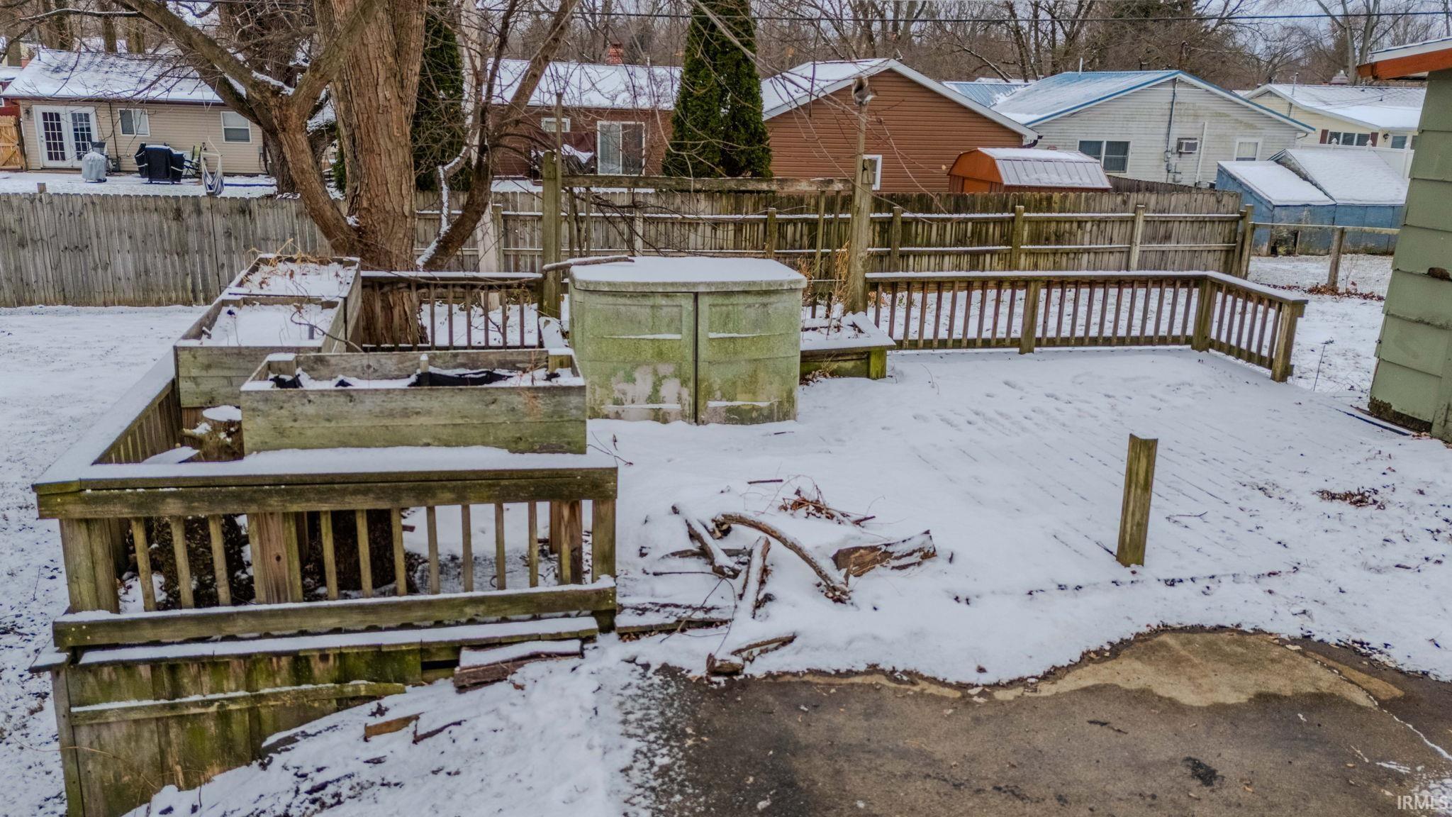 Snow covered deck featuring a fenced backyard and a residential view