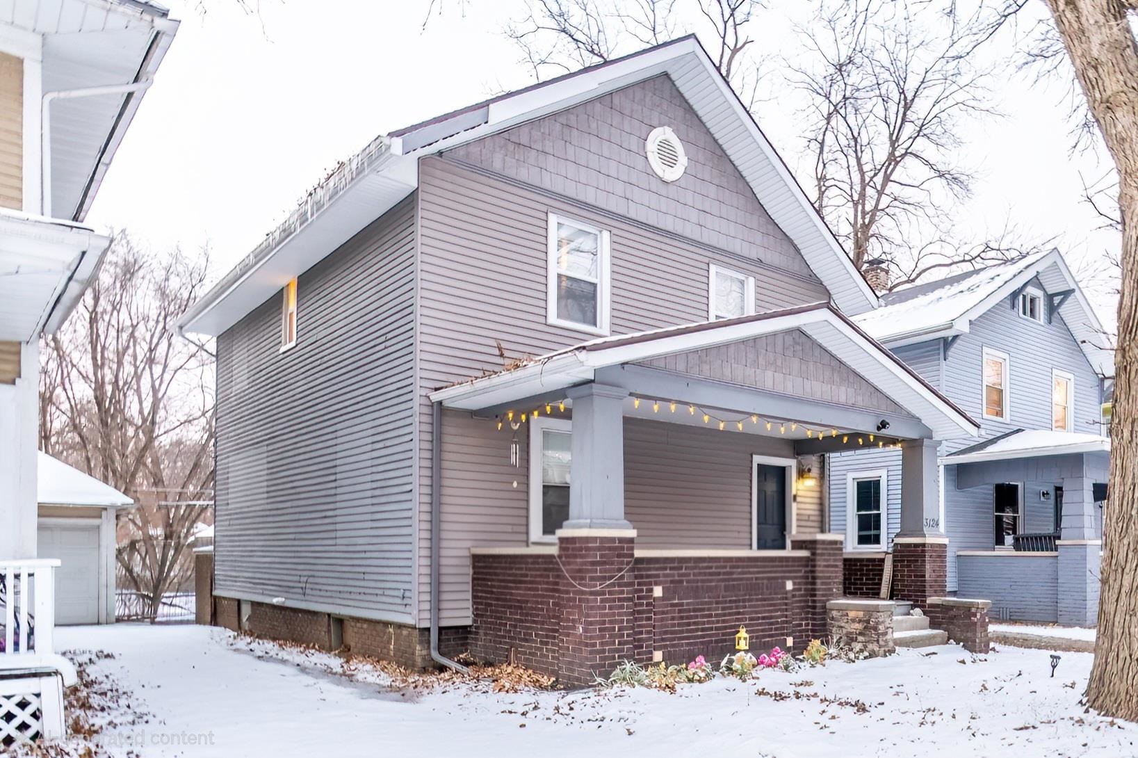 View of front of house featuring a porch, a garage, and an outbuilding