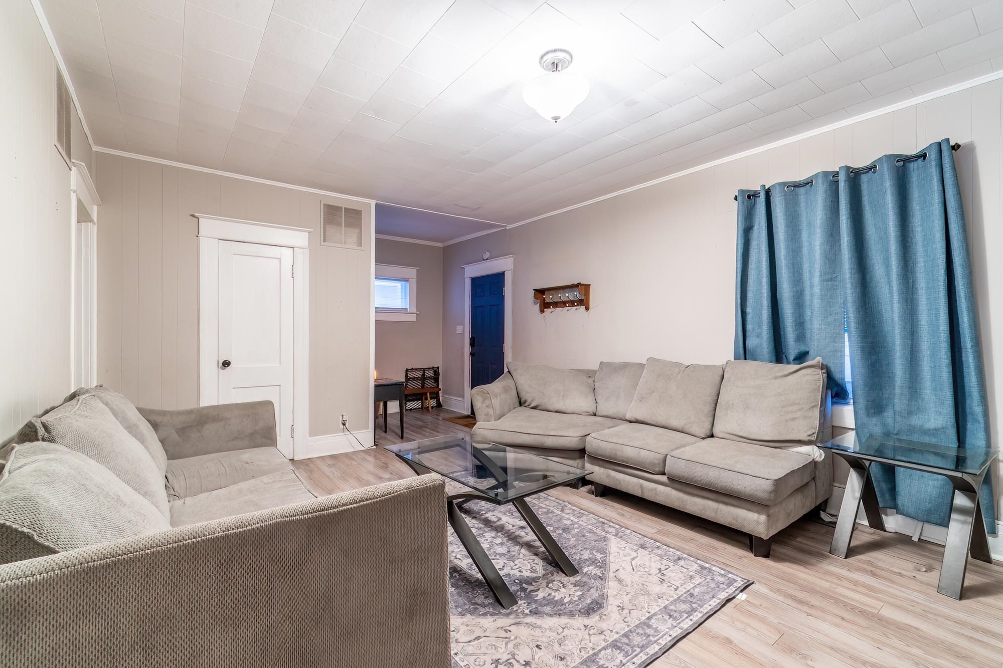 Living area with wood finished floors and crown molding
