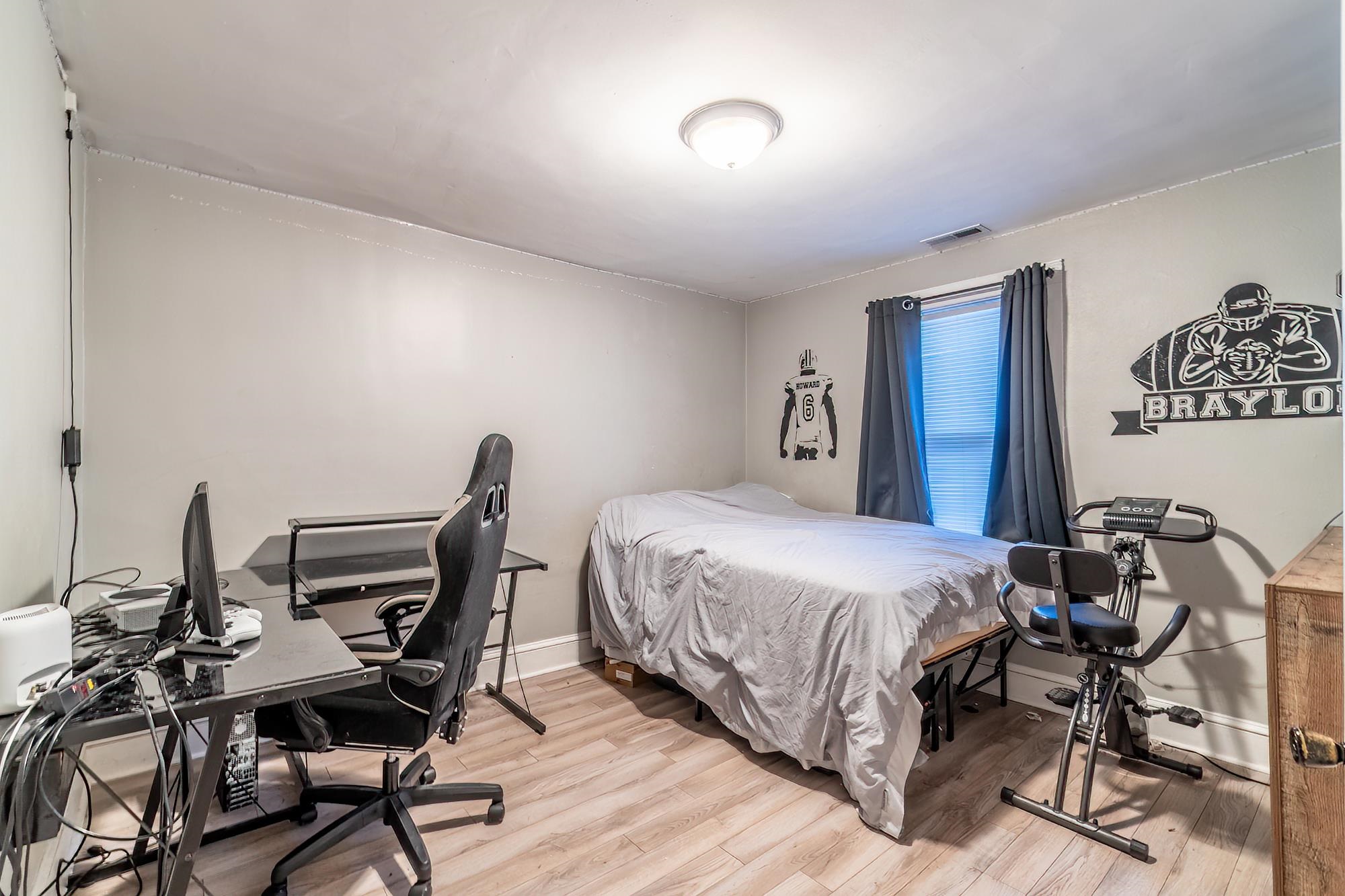 Bedroom with light wood-type flooring and an office area