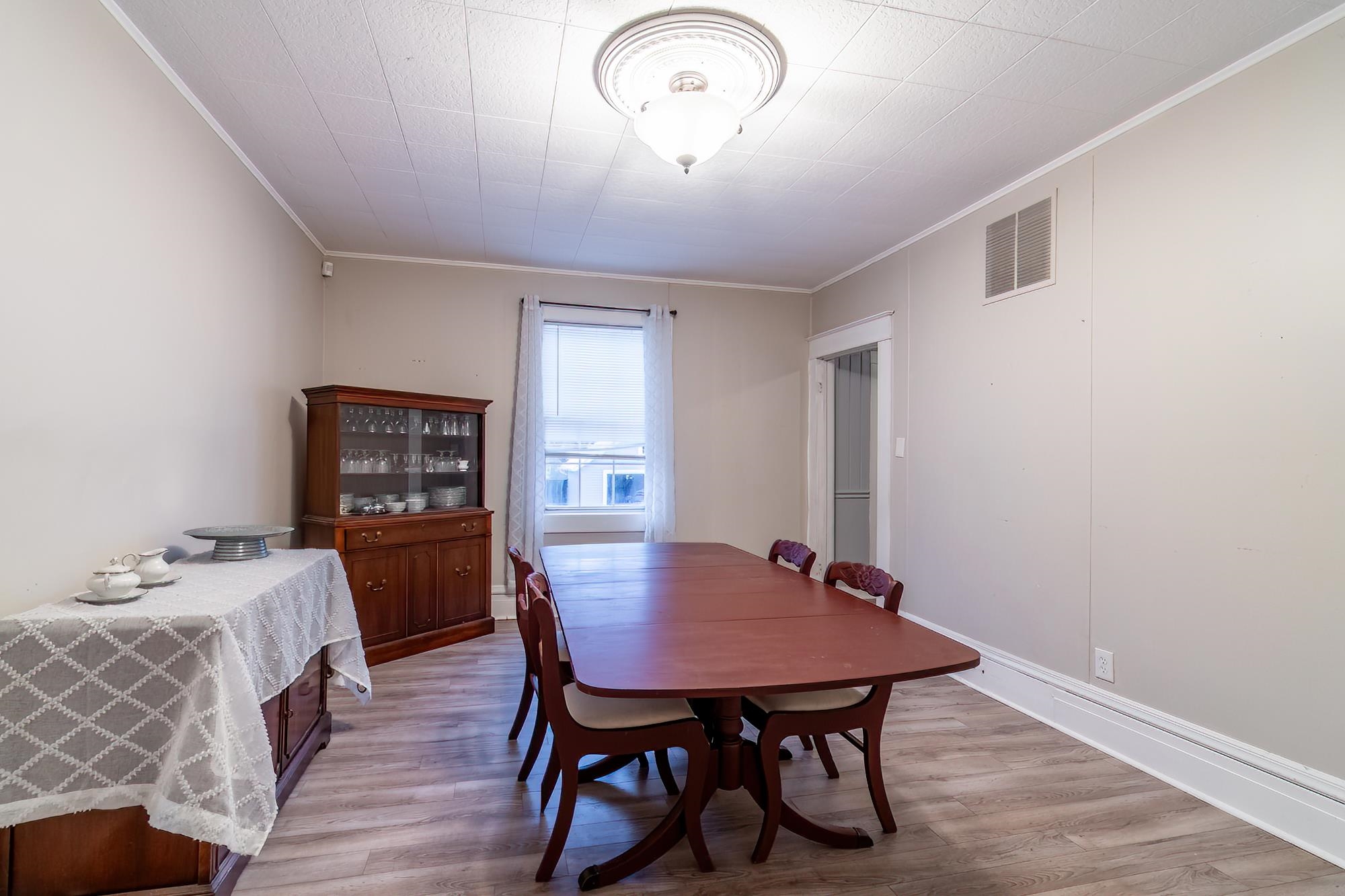 Dining room with ornamental molding and light wood-style flooring