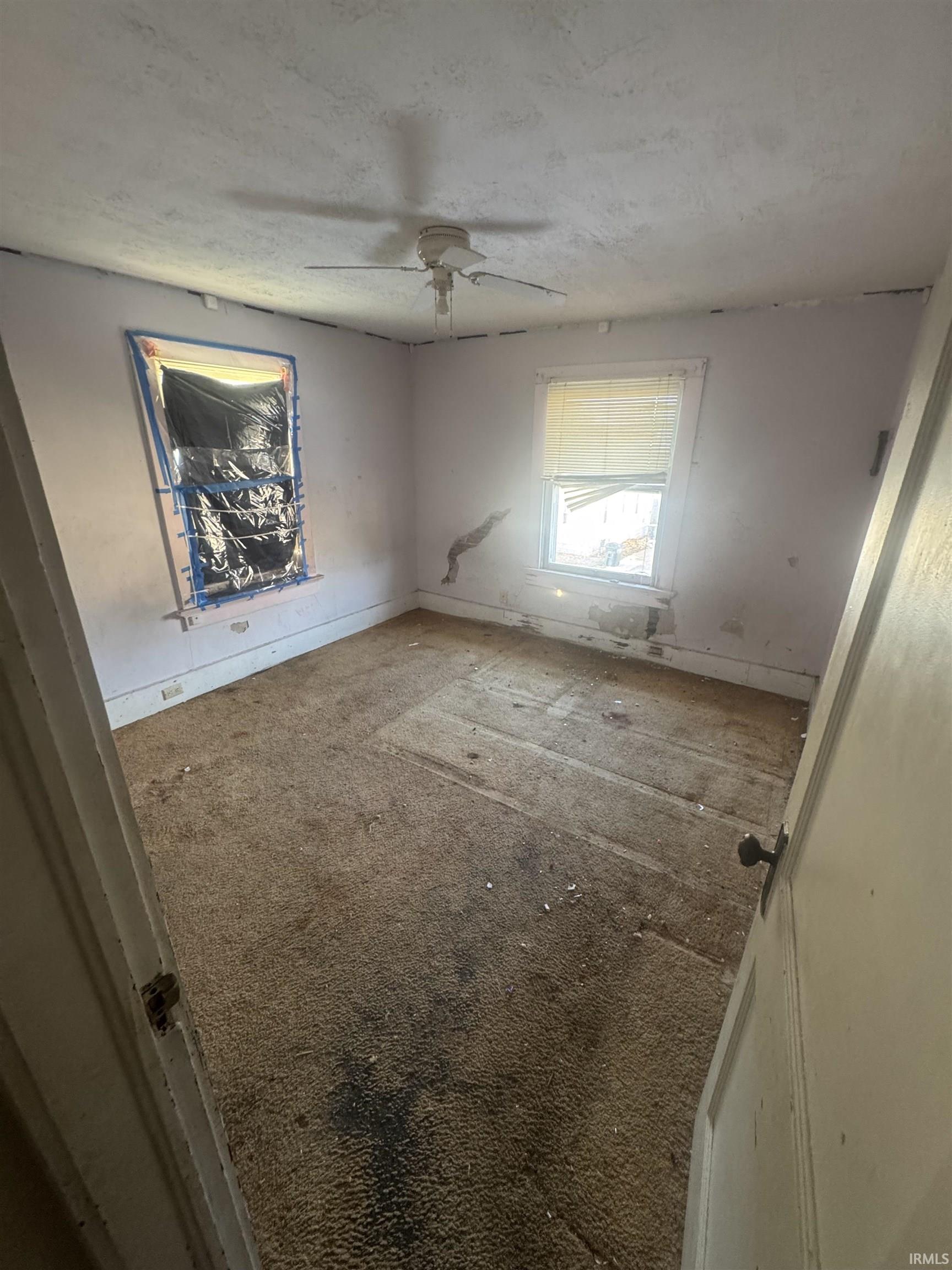Unfurnished bedroom featuring carpet, a ceiling fan, and a textured ceiling