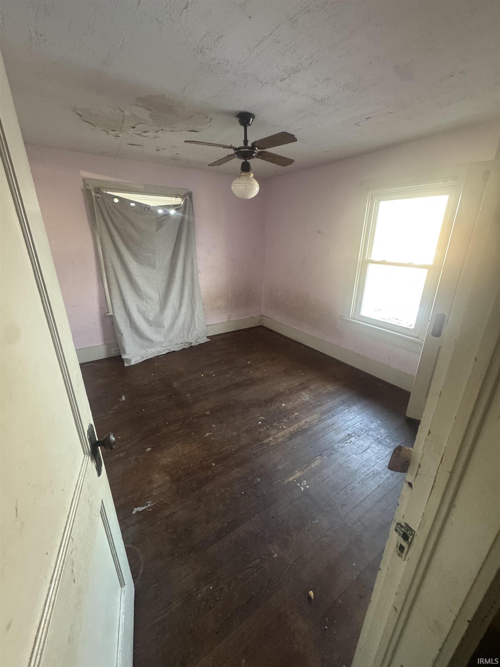 Unfurnished room with dark wood finished floors and ceiling fan