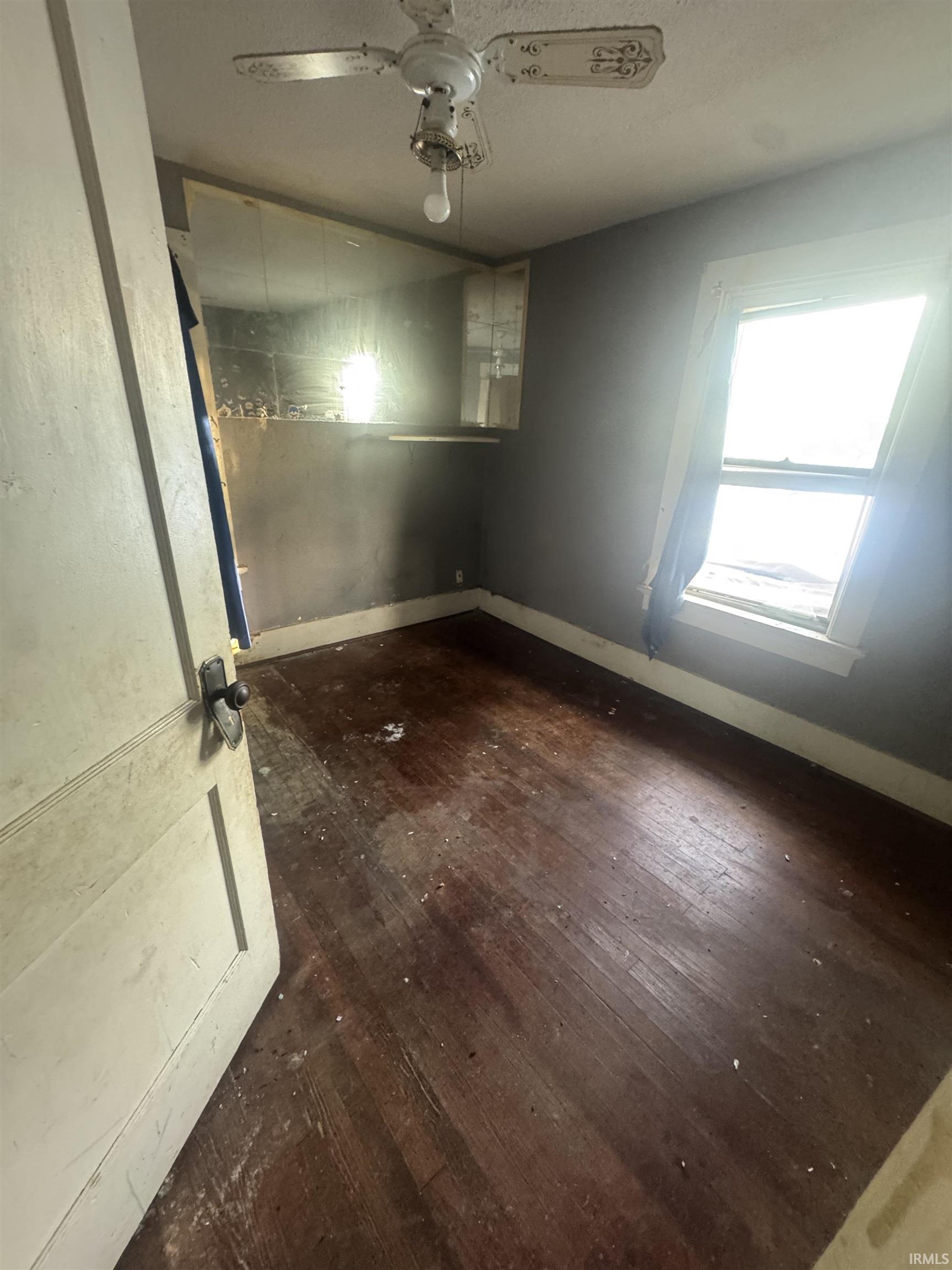 Spare room featuring dark wood-style floors, ceiling fan, and a textured ceiling