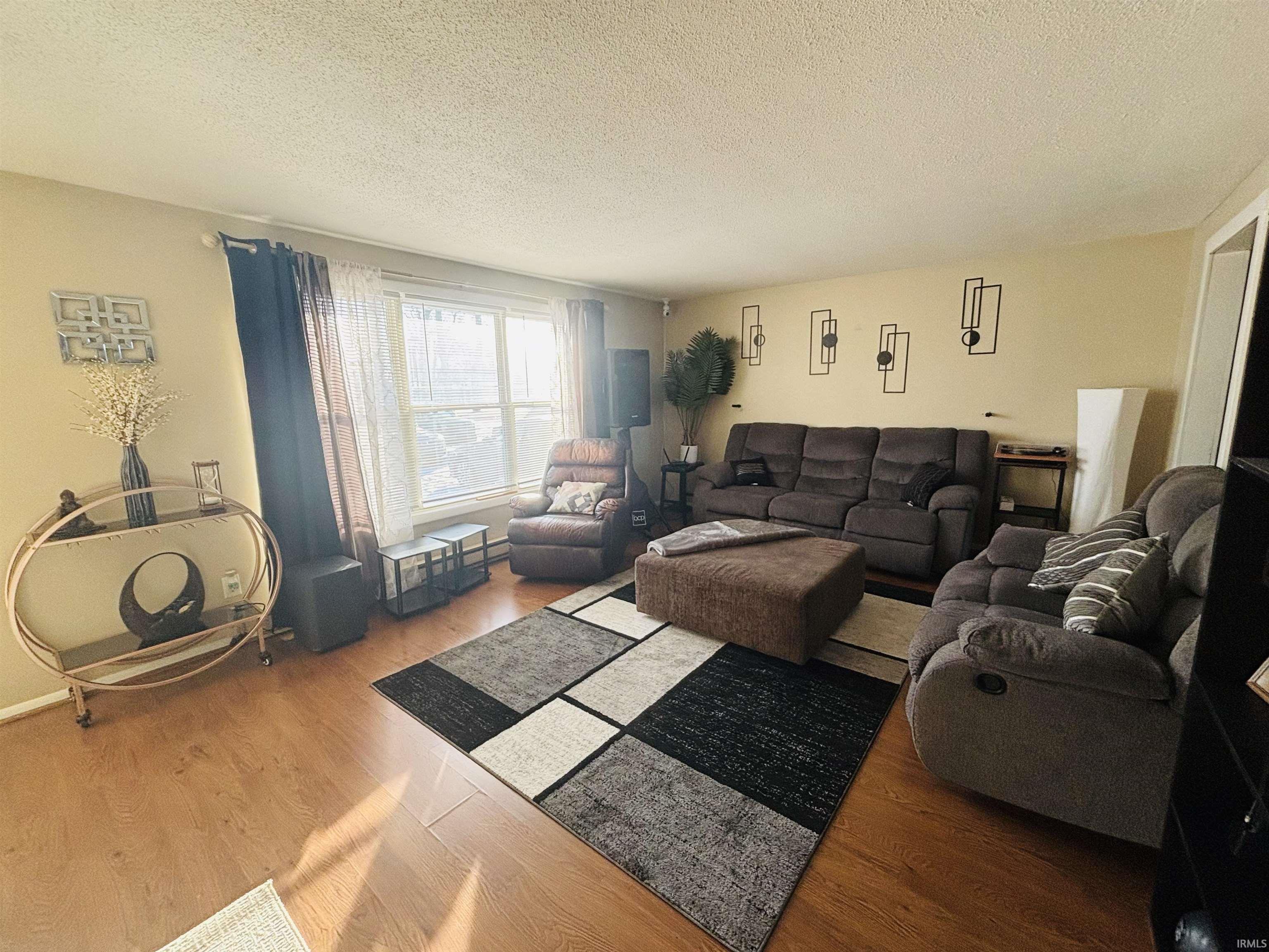 Living room featuring a textured ceiling and wood finished floors