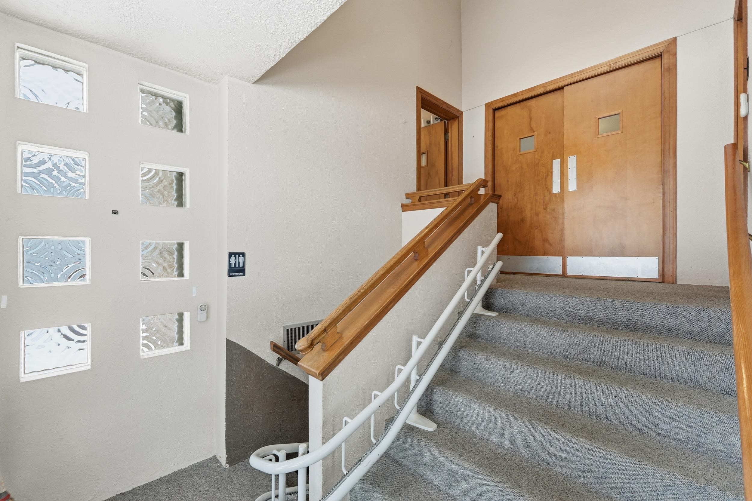 Stairs with carpet flooring and a textured ceiling