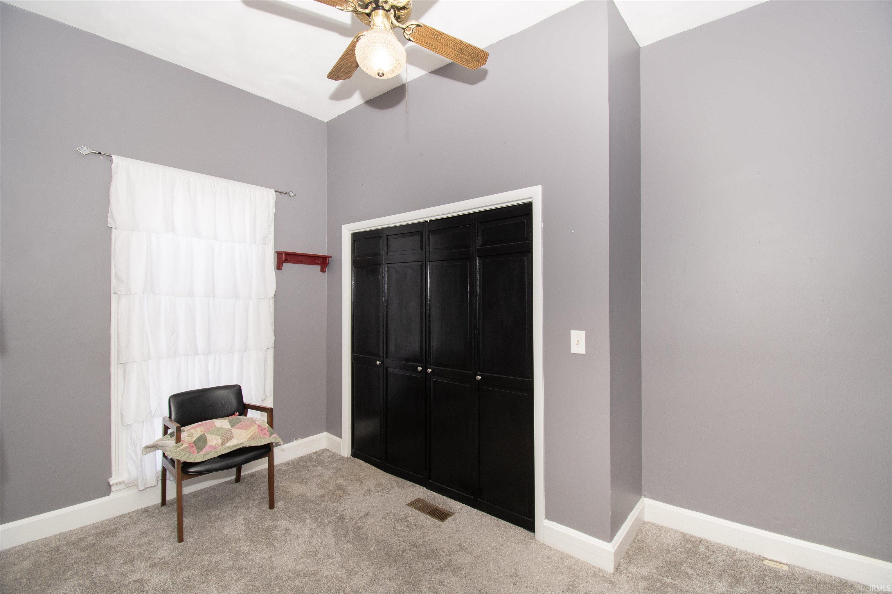 Sitting room featuring carpet floors and a ceiling fan
