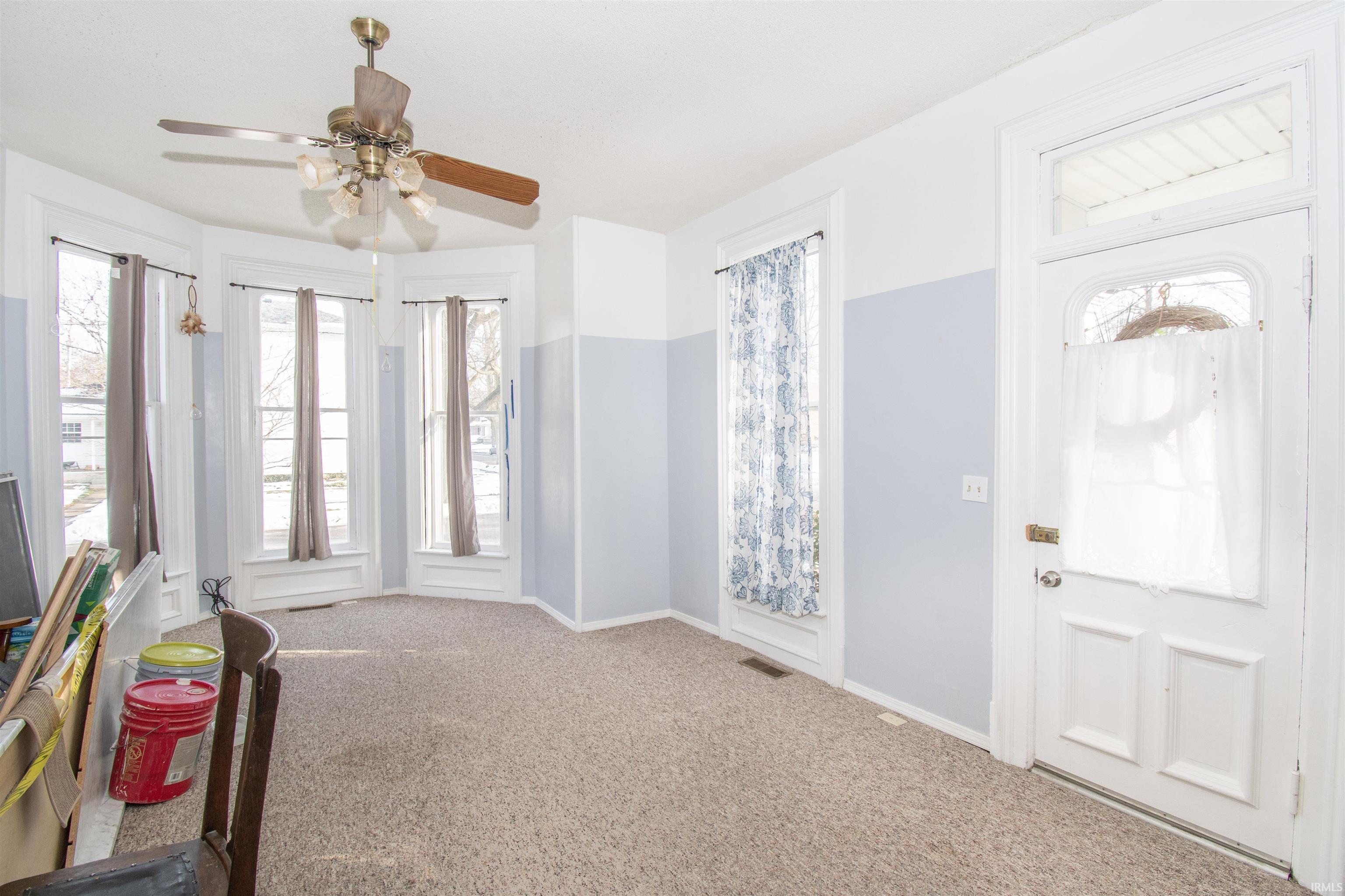 Entryway with carpet floors and ceiling fan