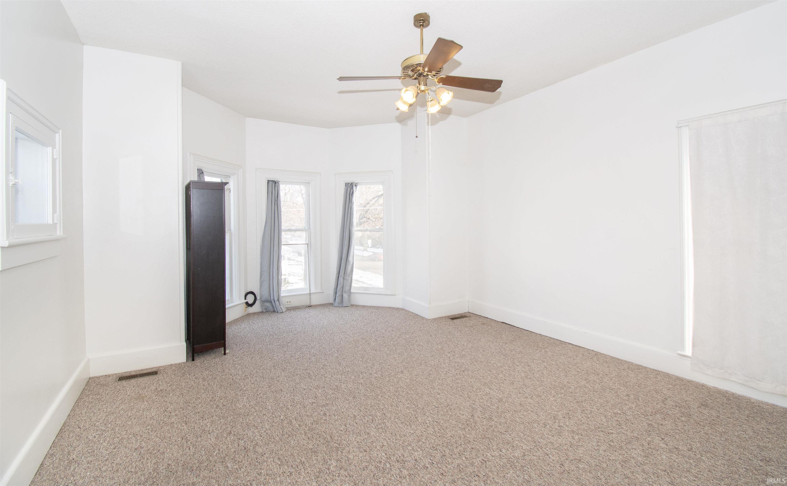 Spare room with light carpet and ceiling fan