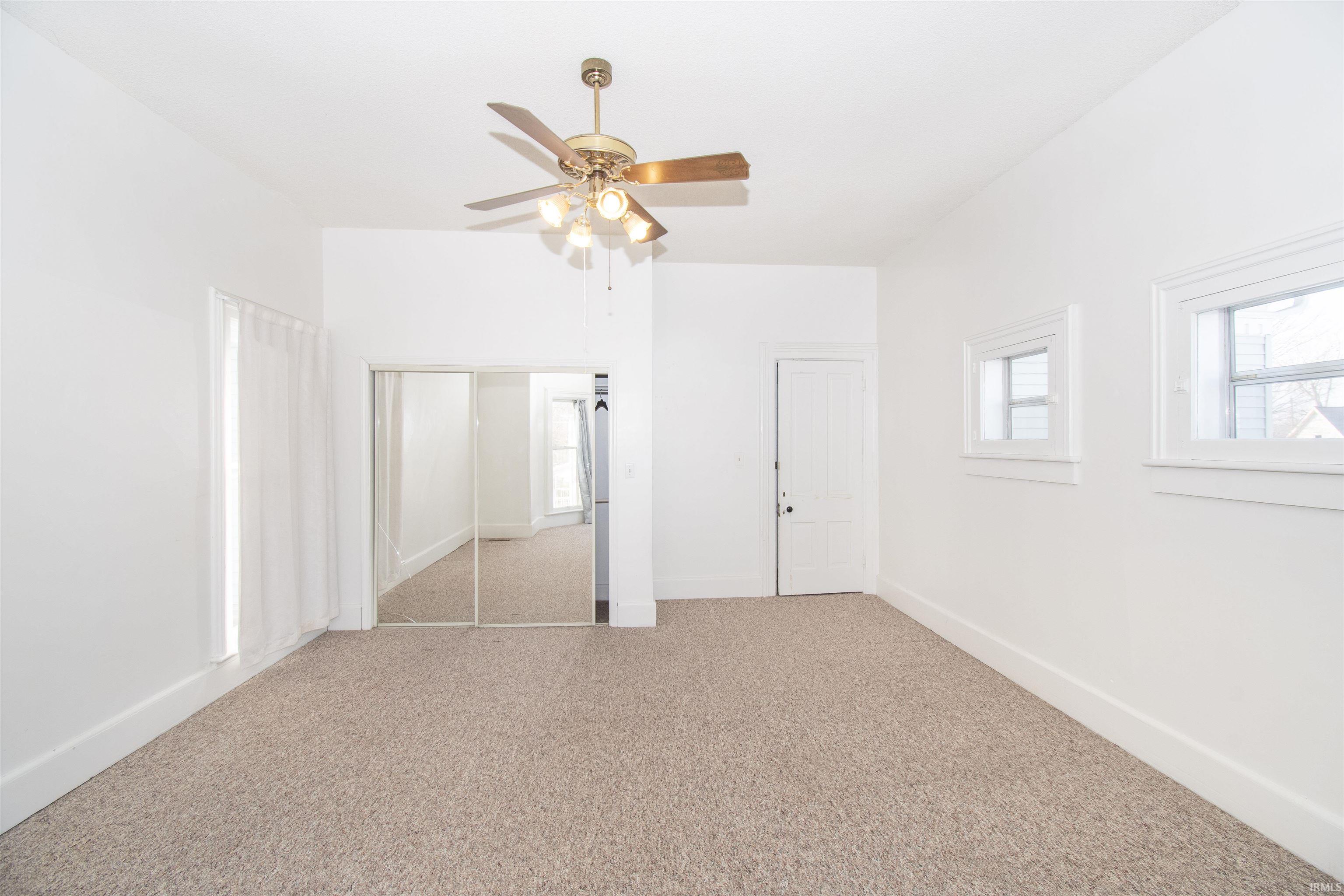 Unfurnished bedroom with a closet, ceiling fan, and carpet