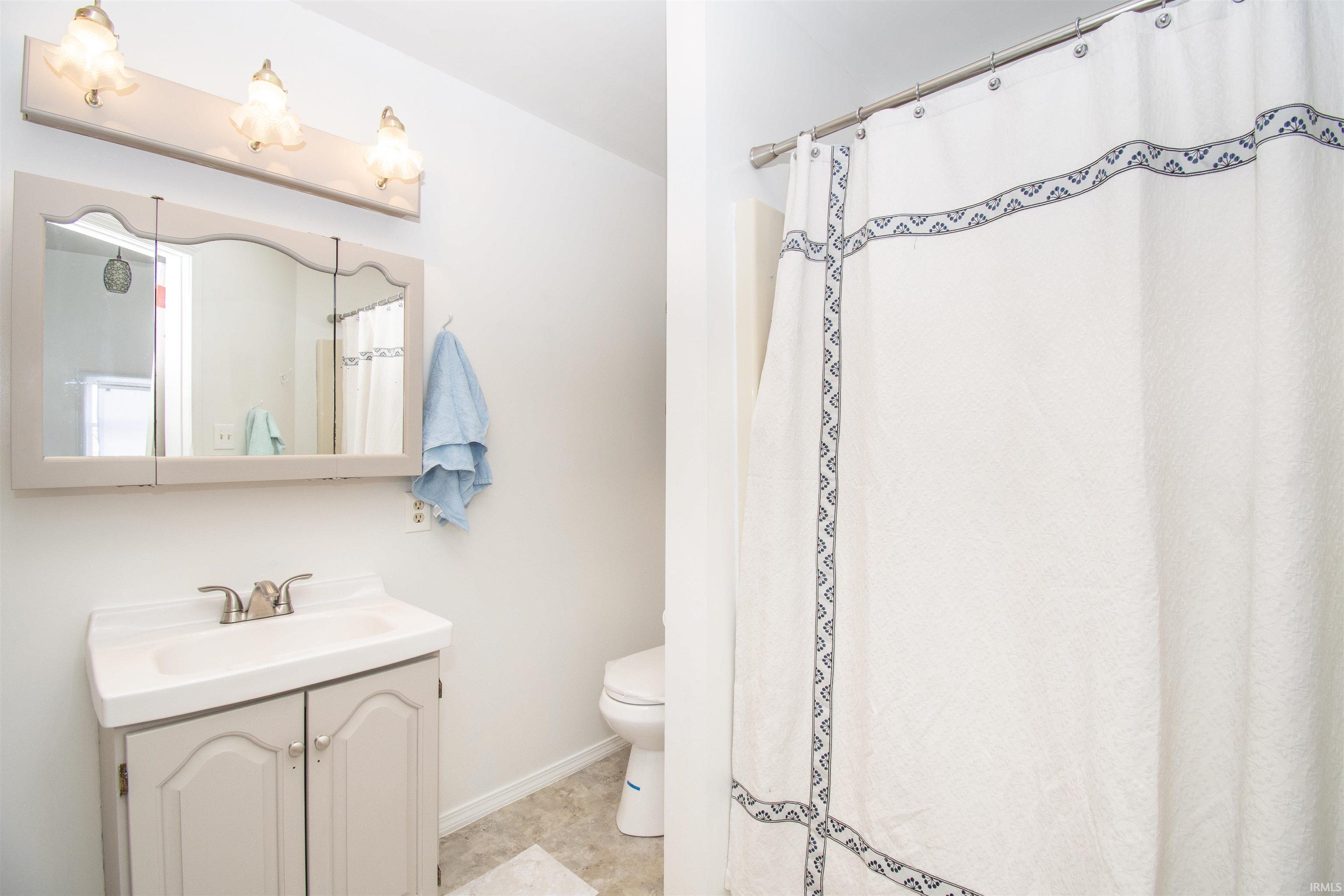 Bathroom with a shower with curtain and vanity