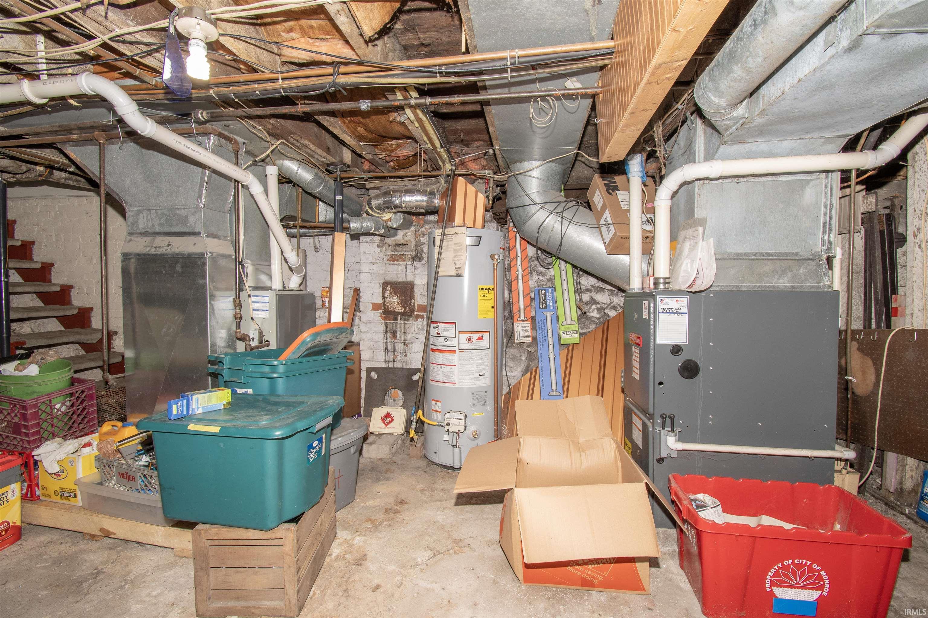 Unfinished below grade area featuring gas water heater and heating unit