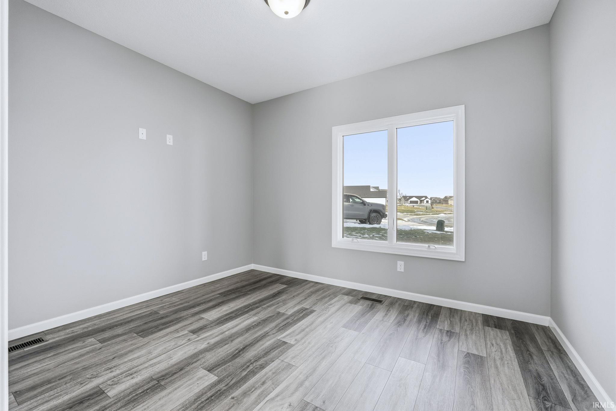 Empty room with baseboards and light wood-style flooring