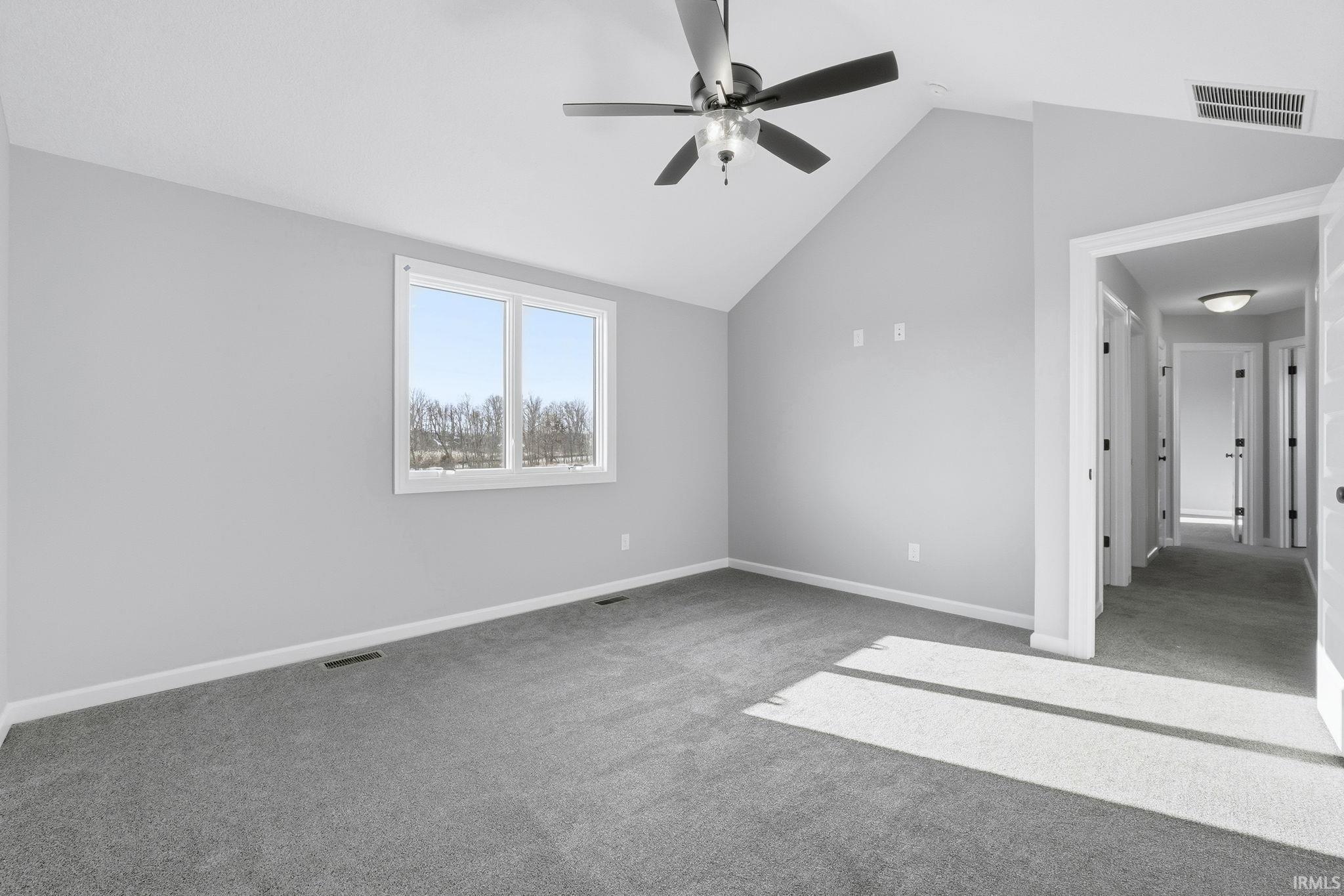 Bonus room featuring light colored carpet, lofted ceiling, and ceiling fan