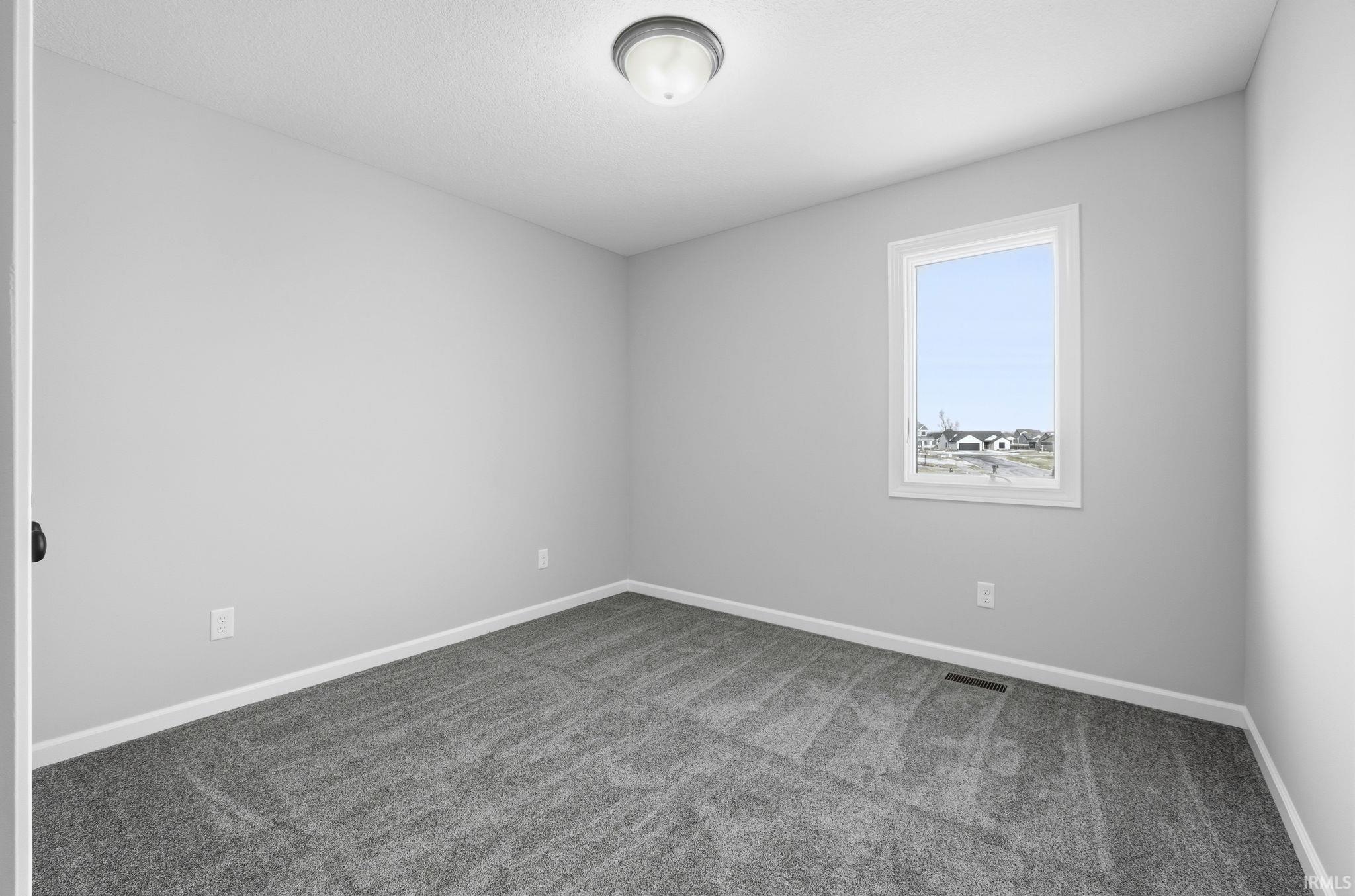 Empty room with carpet and baseboards