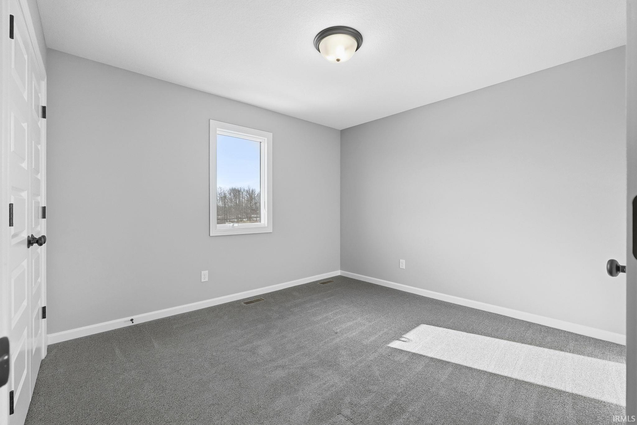 Spare room with carpet and baseboards