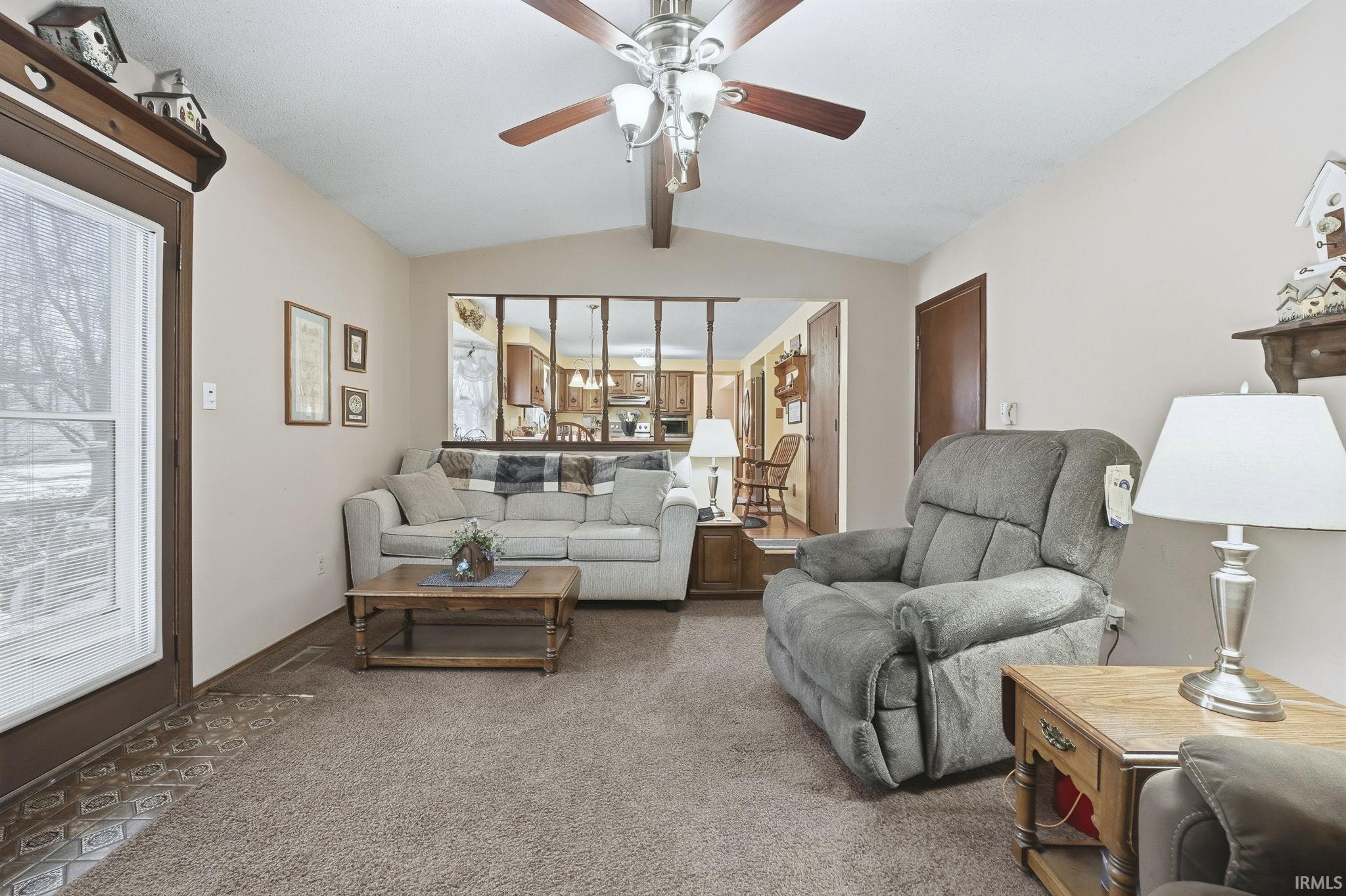 Carpeted living area with a ceiling fan