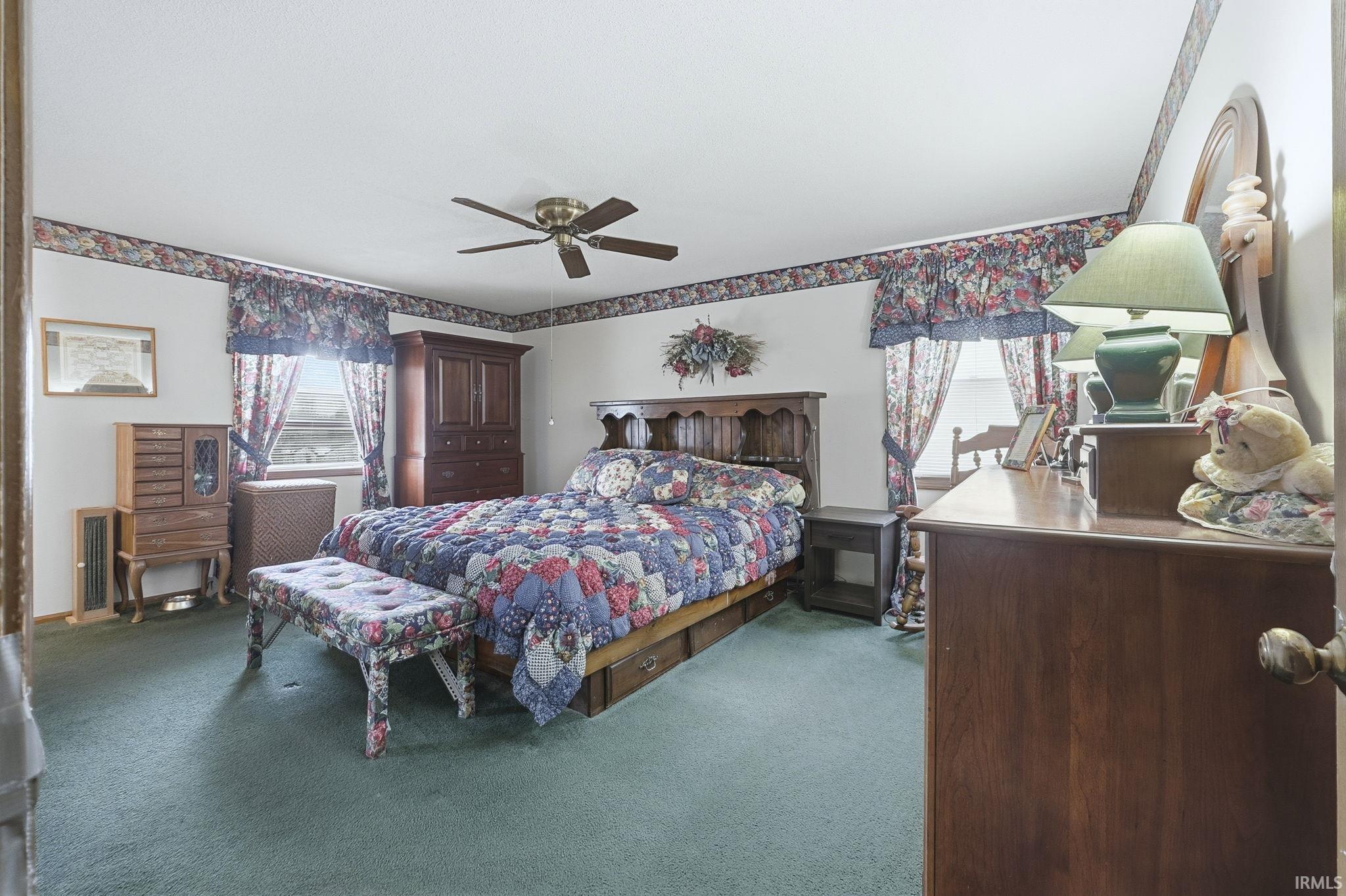 Carpeted bedroom with a ceiling fan