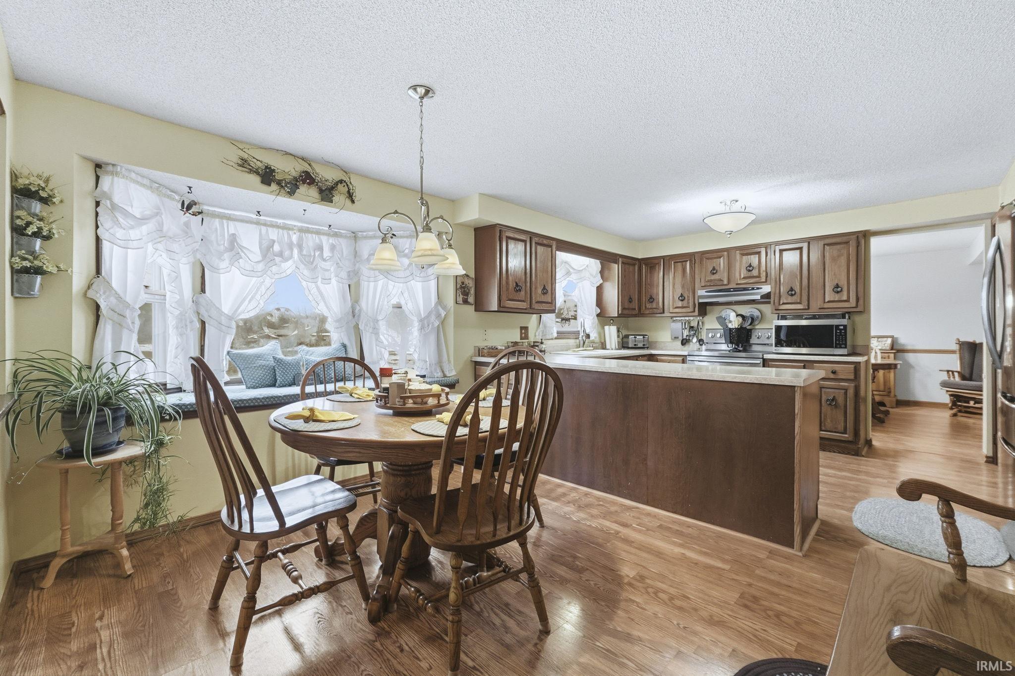 Dining space featuring a textured ceiling and light wood-type flooring