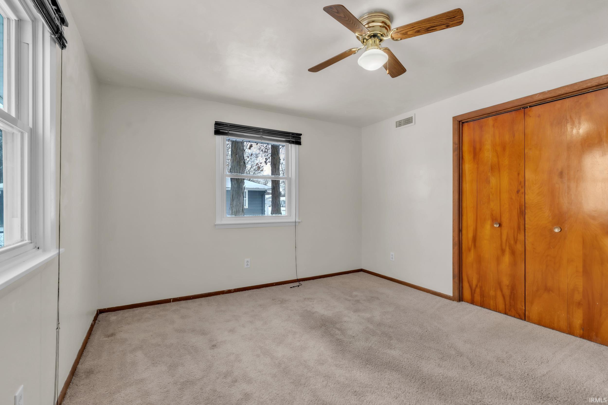 Unfurnished bedroom with carpet floors, a ceiling fan, and a closet