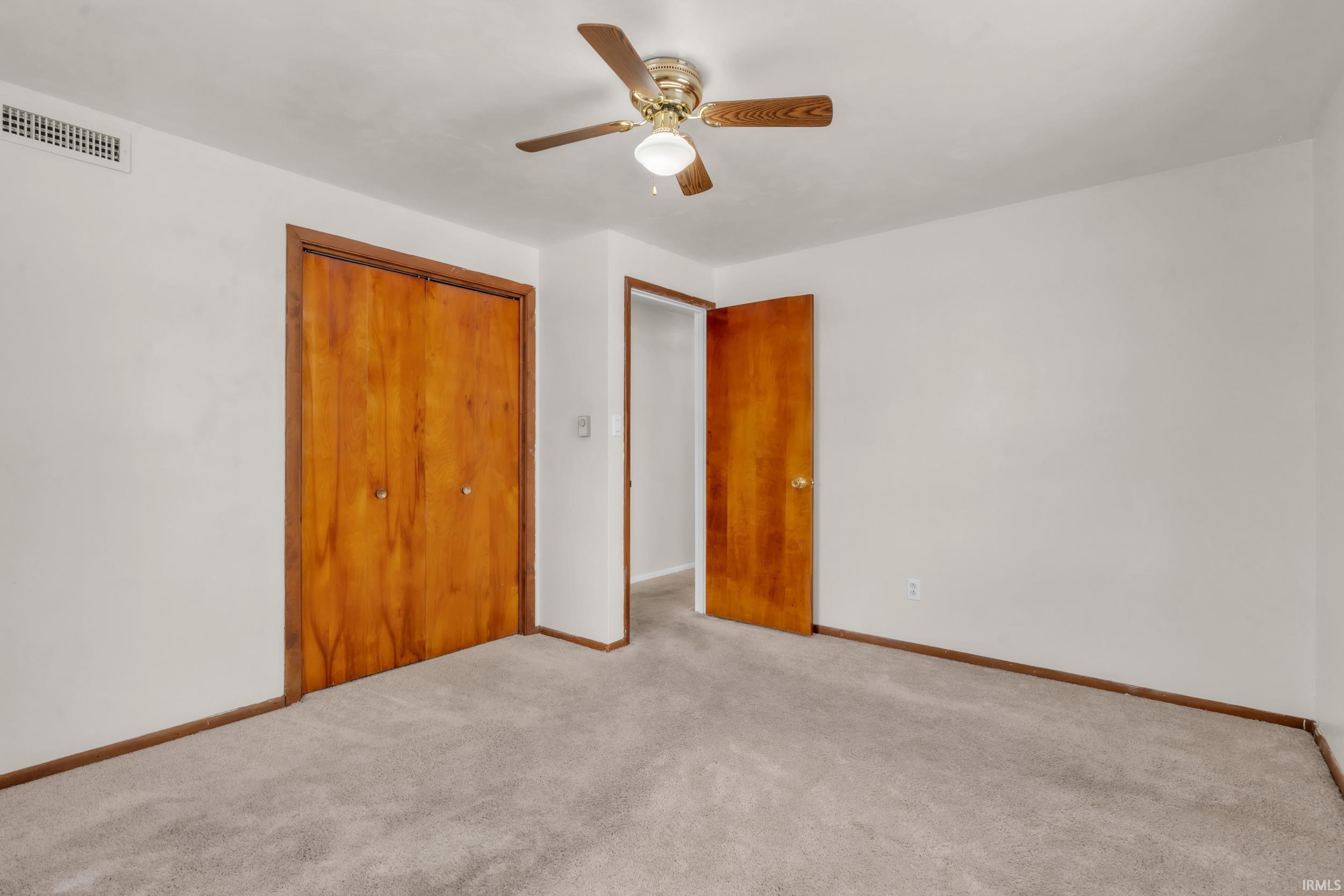 Unfurnished bedroom featuring ceiling fan, a closet, and carpet floors