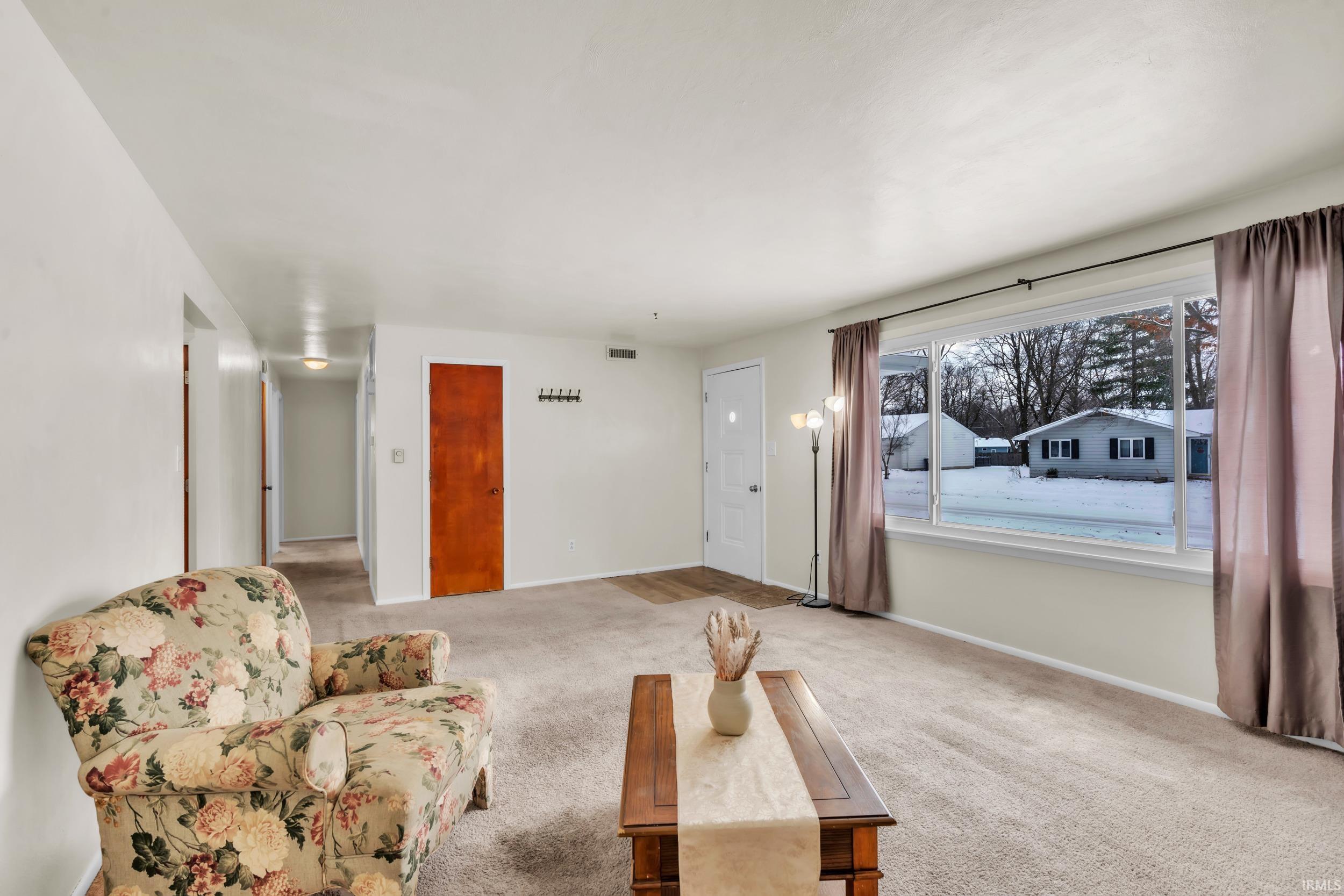 Carpeted living area featuring baseboards