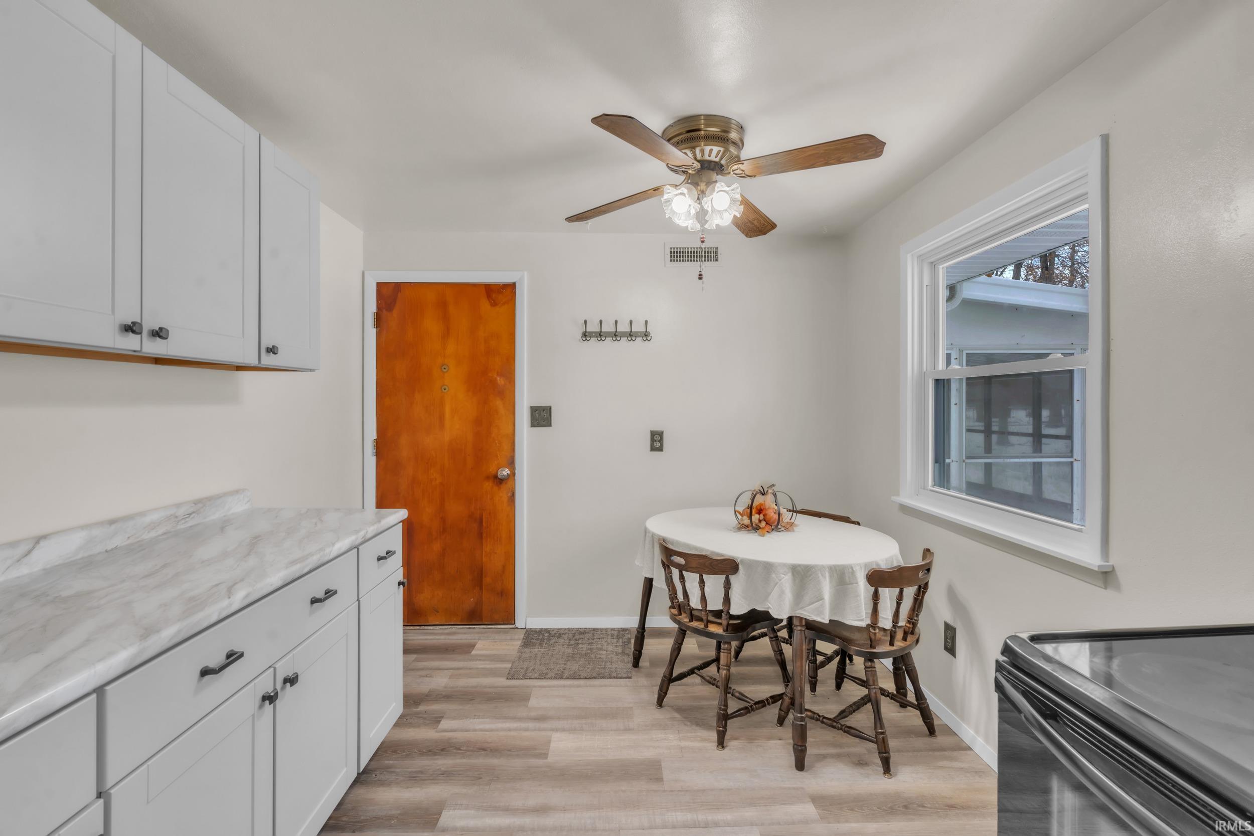 Dining space featuring light wood-type flooring and a ceiling fan