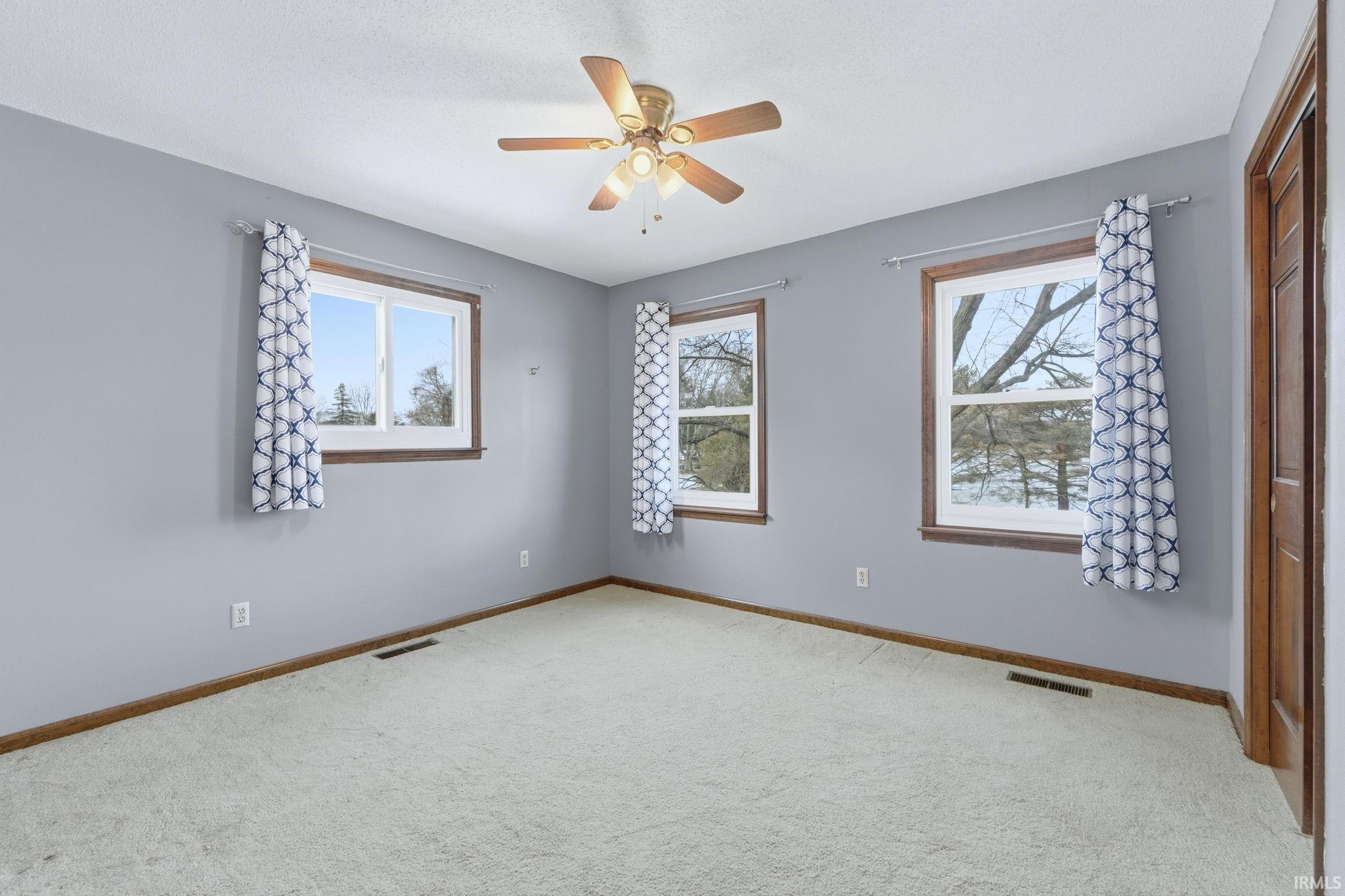 Unfurnished room with light carpet and a ceiling fan