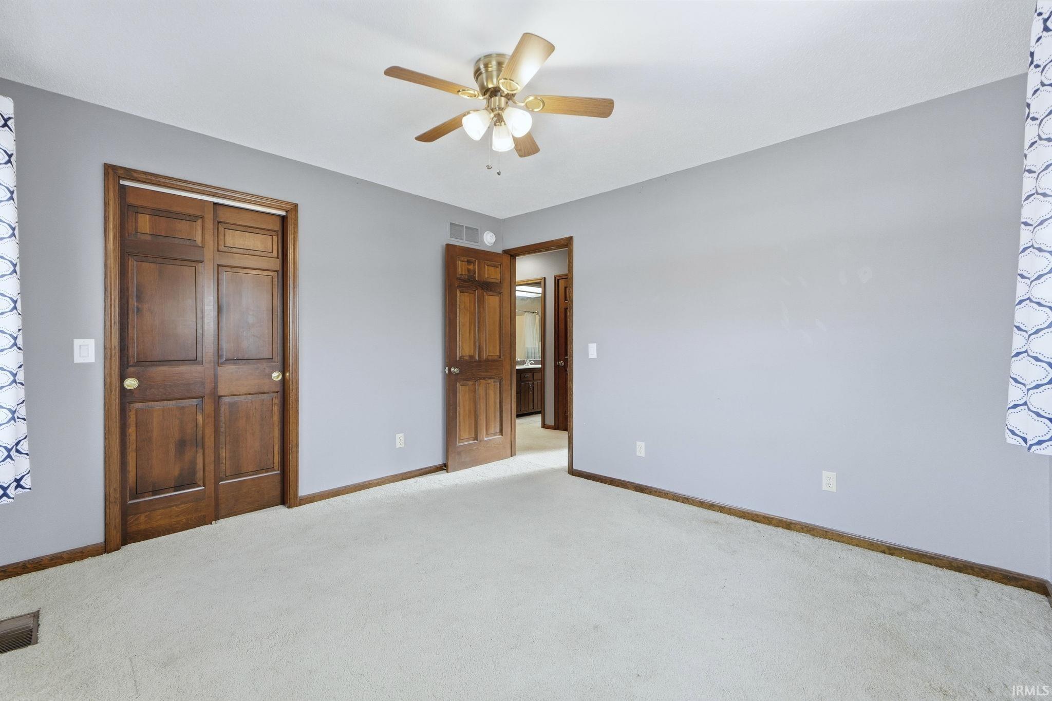 Unfurnished bedroom with a ceiling fan, carpet, and a closet
