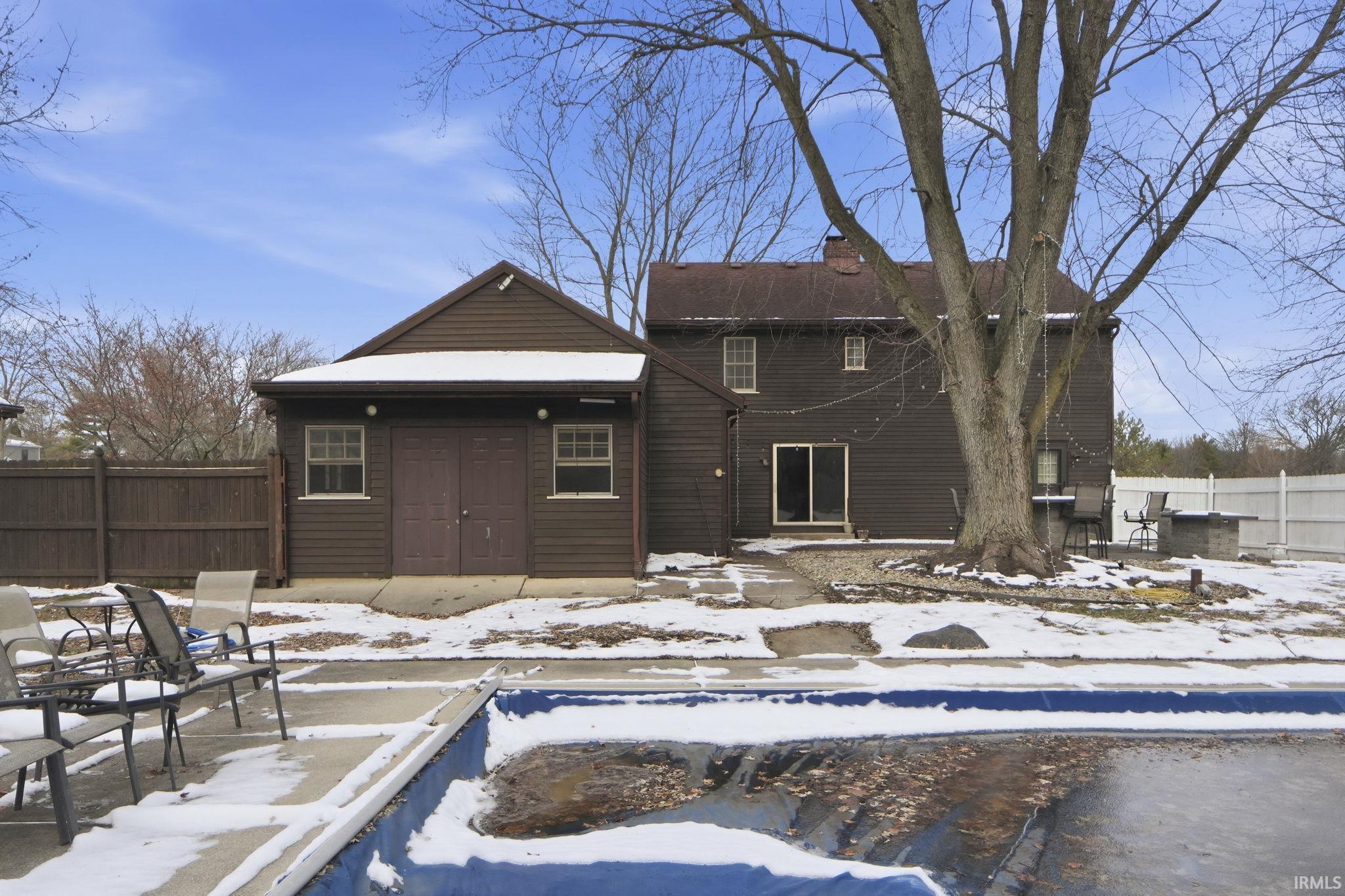 Snow covered property featuring a chimney