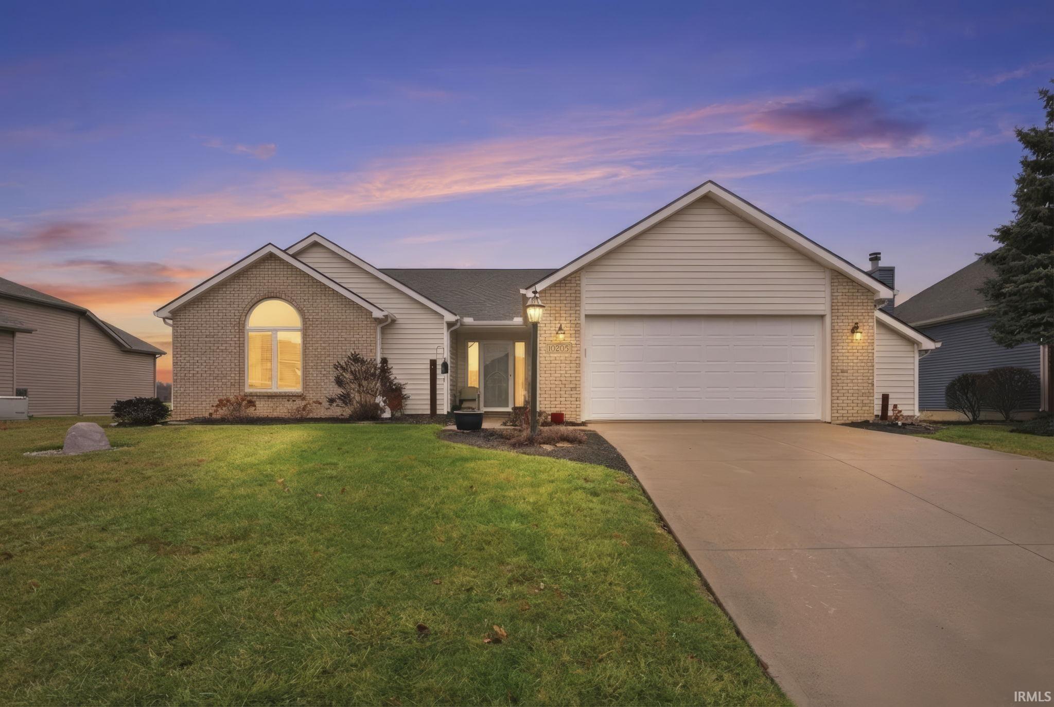 Ranch-style house with brick siding, driveway, a front lawn, and a garage