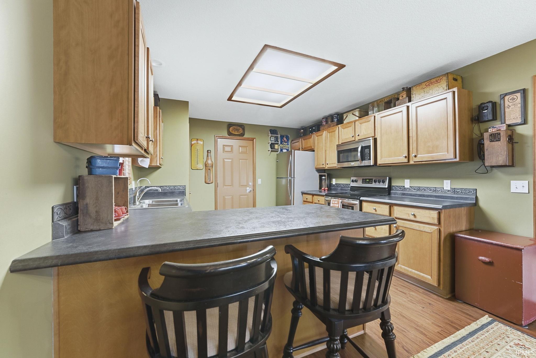 Kitchen with stainless steel appliances, a breakfast bar area, and dark countertops