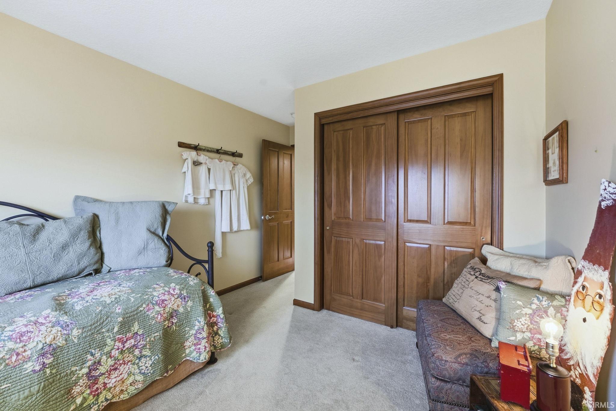 Bedroom with a closet and light colored carpet