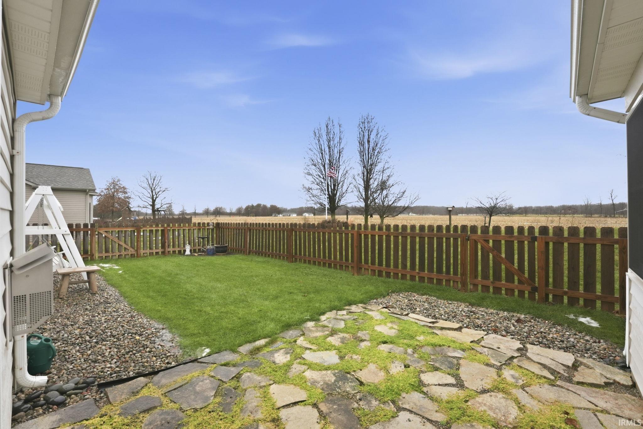 Fenced backyard featuring a view of rural / pastoral area