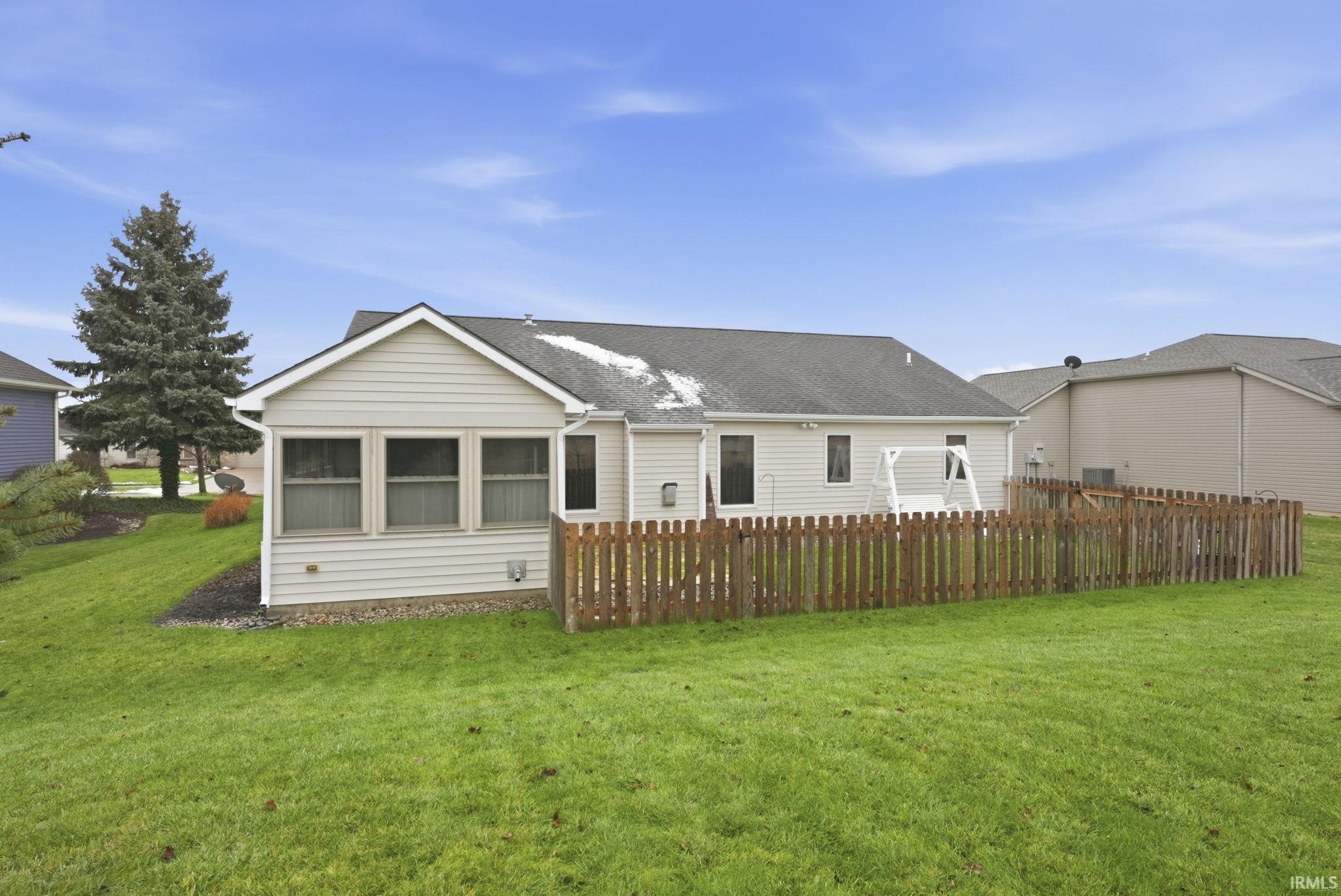 Back of property featuring roof with shingles and a sunroom