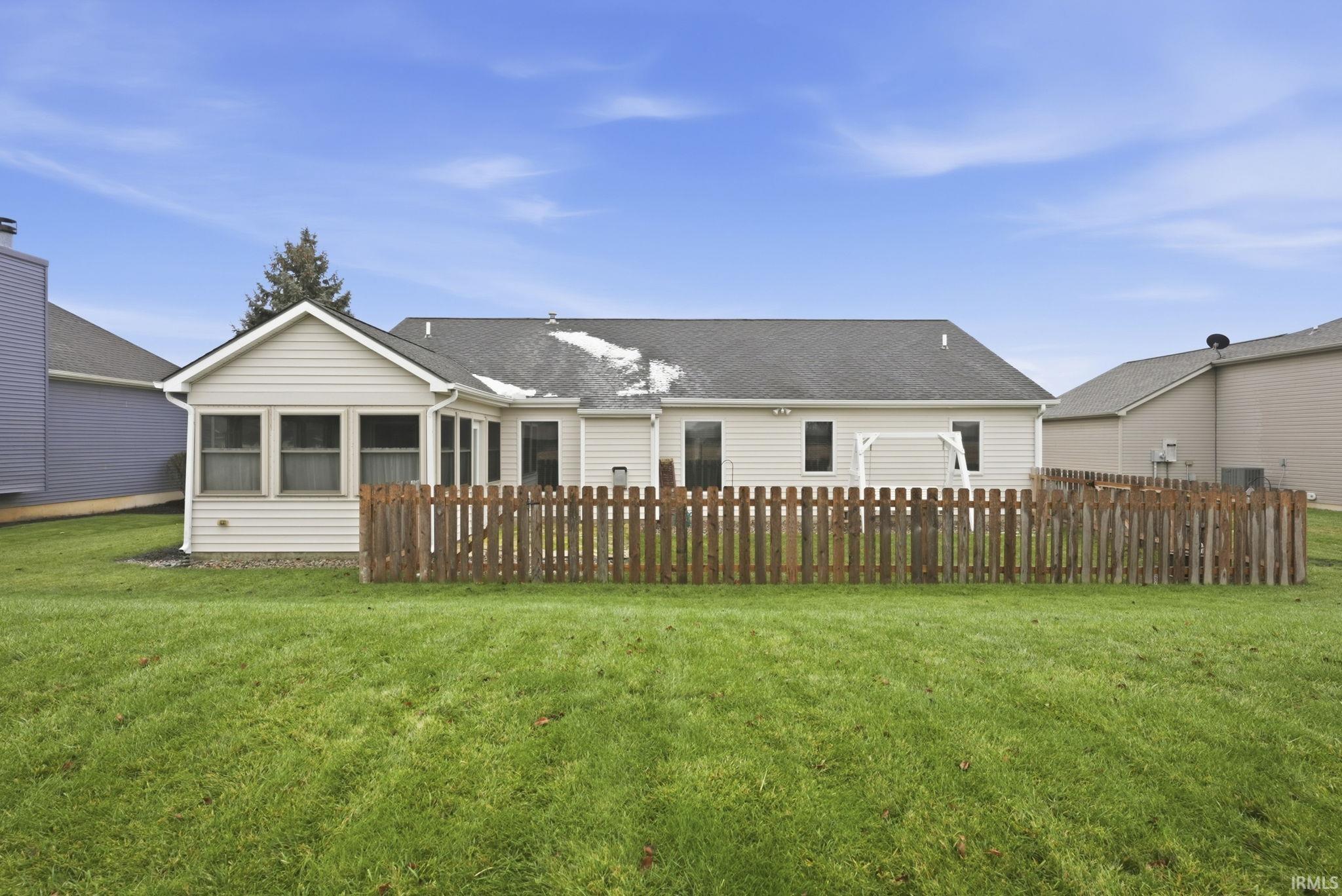Back of house with a sunroom and a shingled roof
