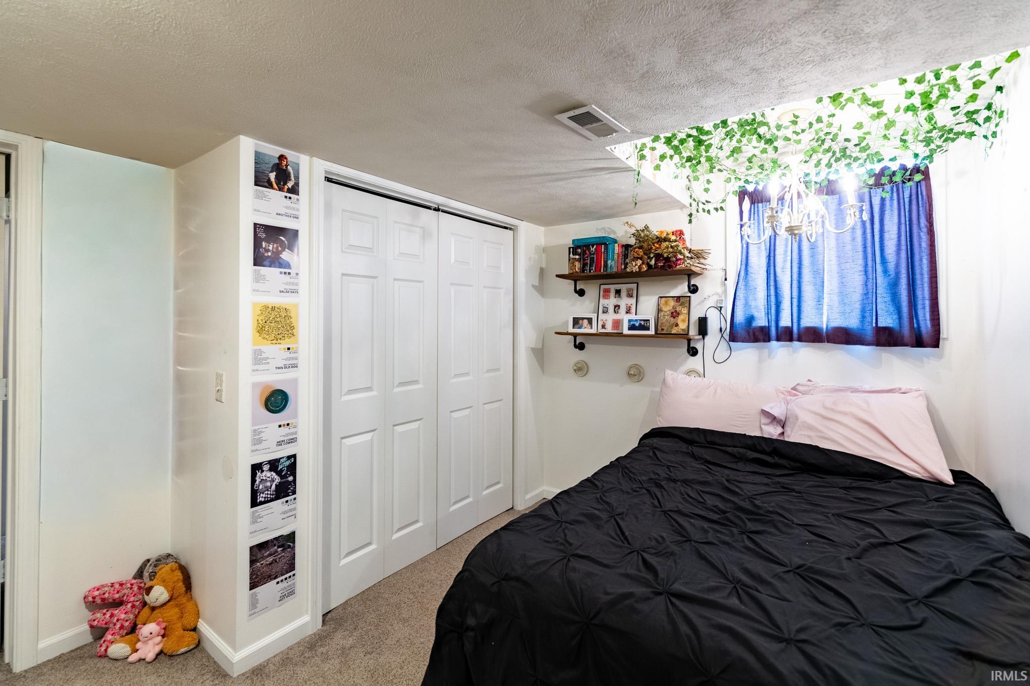 Bedroom featuring a textured ceiling, carpet, and a closet