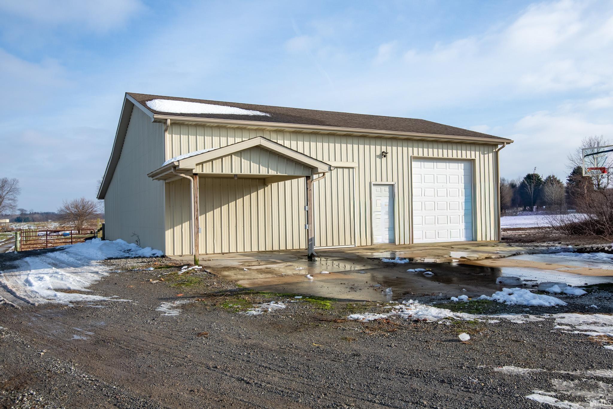 Exterior space featuring an outdoor structure and a shingled roof
