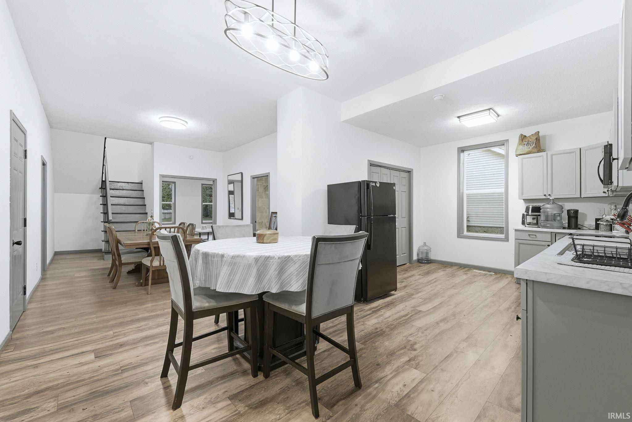 Dining room with light wood-style flooring and stairway
