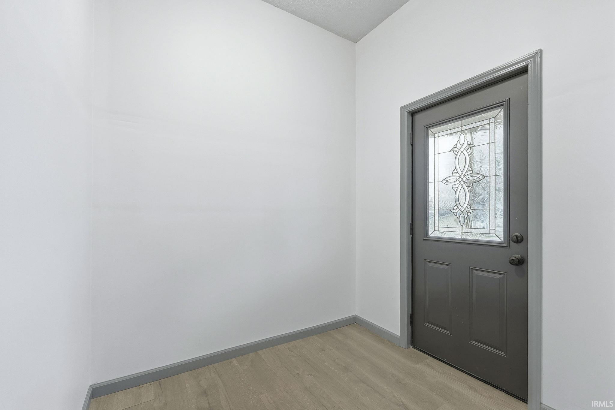 Foyer featuring light wood finished floors and baseboards