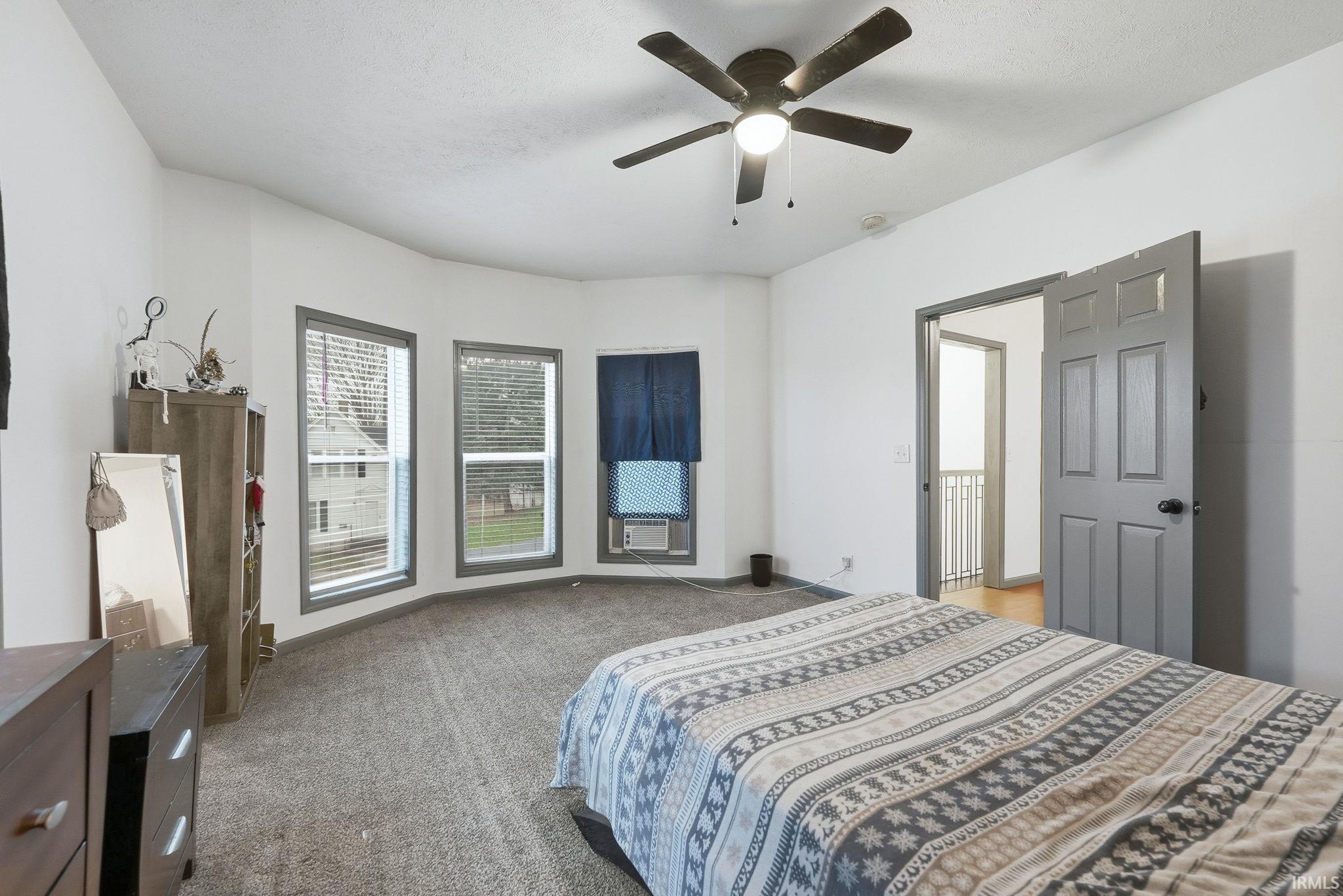 Bedroom with light colored carpet and ceiling fan