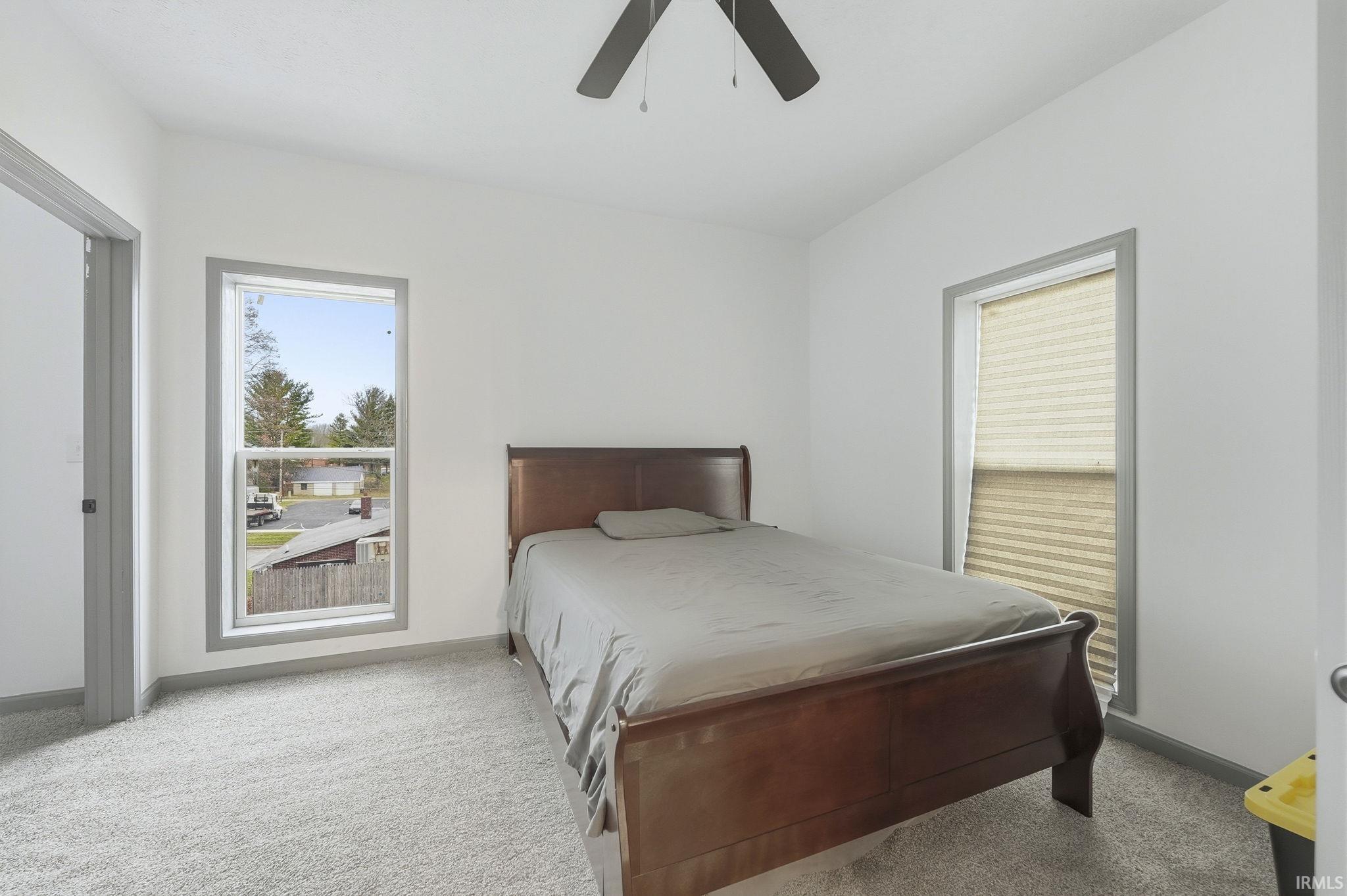 Carpeted bedroom with baseboards and a ceiling fan