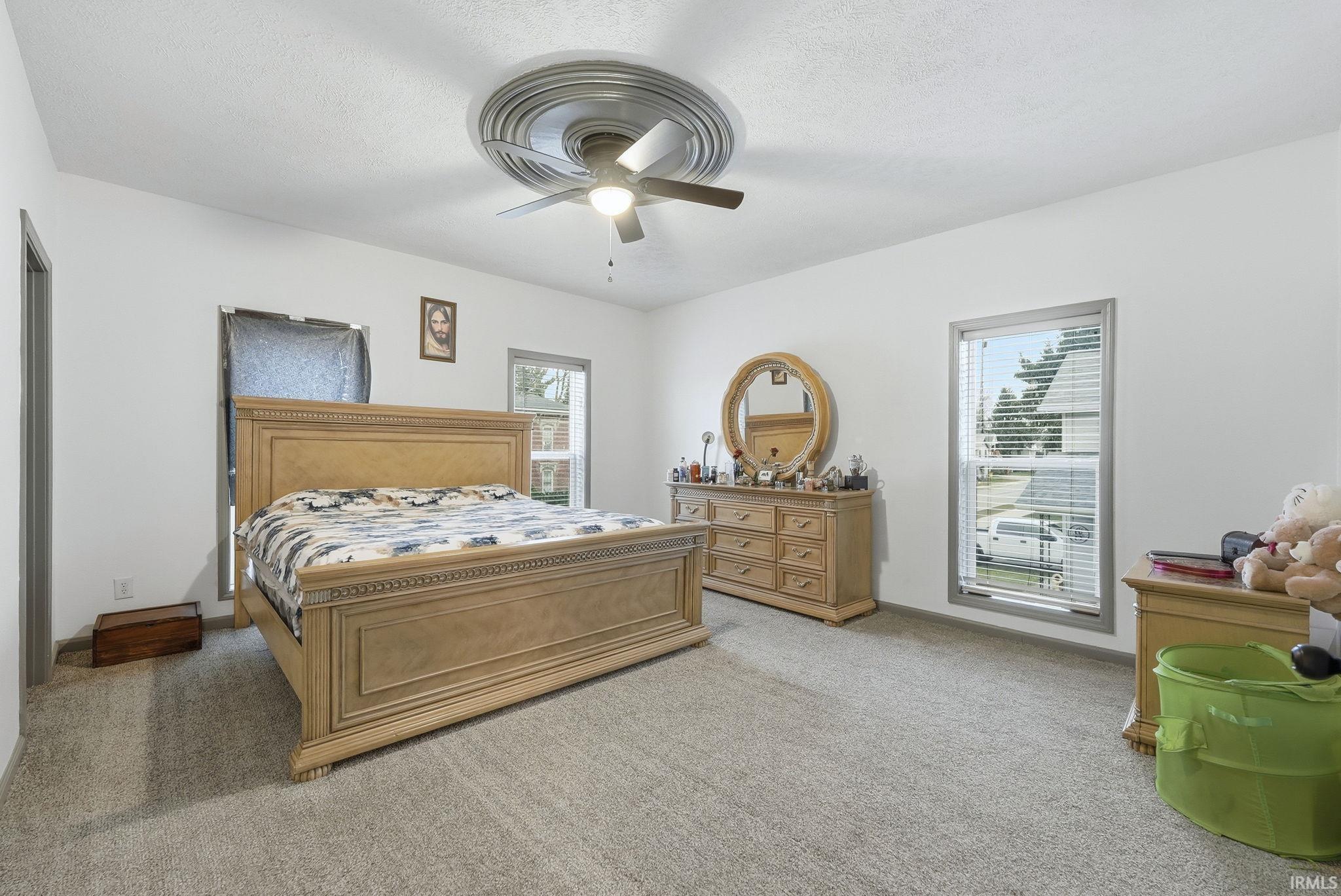 Bedroom featuring light colored carpet and a ceiling fan