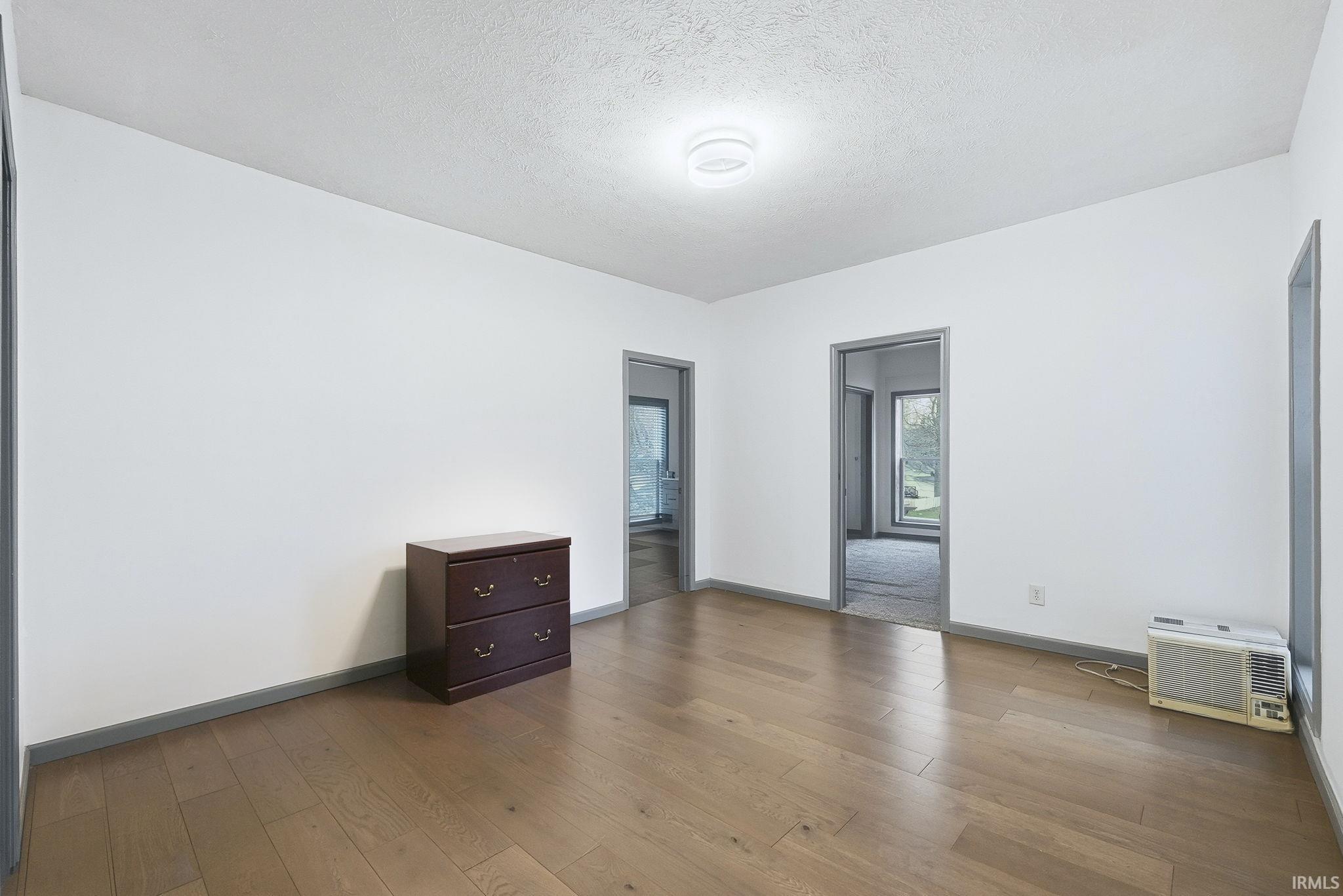Unfurnished room with a textured ceiling and hardwood / wood-style floors
